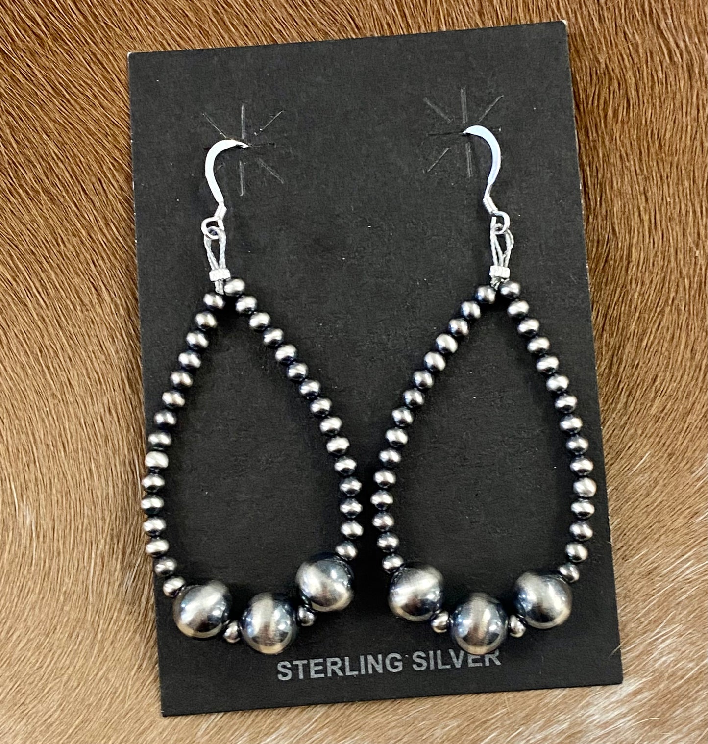 Beautiful and comfortable hand-strung Navajo pearl earrings made of sterling silver. Navajo pearl earrings with a hook closure look well with formal as well as informal outfits. The ideal Navajo pearl earrings are simple yet stylish at the same time. The perfect earrings to add to your collection of jewelry or give as a gift to someone you really care about. Each silver component is soldered shut for stability and peace of mind.  Size: 2 3/4" inches length earrings  Stone: Navajo Pearls