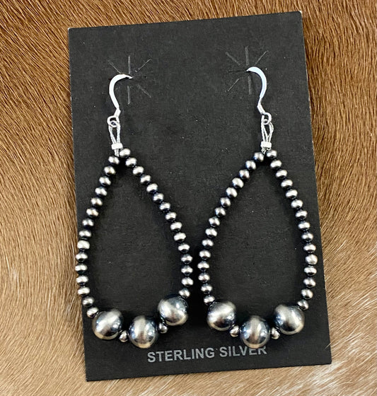 Beautiful and comfortable hand-strung Navajo pearl earrings made of sterling silver. Navajo pearl earrings with a hook closure look well with formal as well as informal outfits. The ideal Navajo pearl earrings are simple yet stylish at the same time. The perfect earrings to add to your collection of jewelry or give as a gift to someone you really care about. Each silver component is soldered shut for stability and peace of mind.  Size: 2 3/4" inches length earrings  Stone: Navajo Pearls