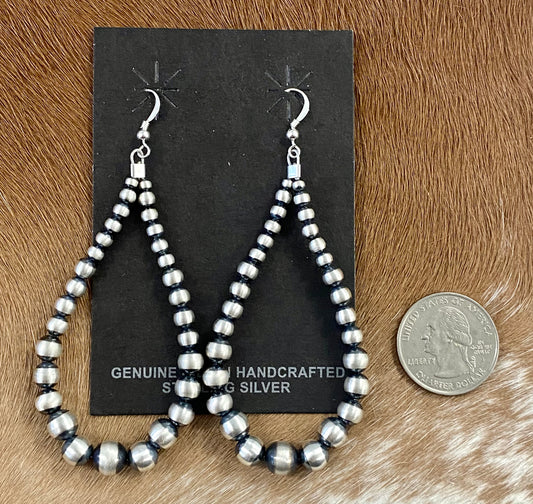 Hand-strung sterling silver Navajo pearl earrings that are easy to wear and incredibly beautiful. Earrings composed of Navajo pearls and secured by a hook go nicely with a formal or casual outfit. The perfect Navajo pearl earrings may be both simple and fashionable. The ideal earrings to add to your jewelry collection or give as a present to someone you love deeply. To provide sturdiness and peace of mind, each silver component is soldered shut. Size: 3.5" inches length earrings Stone: Navajo Pearls