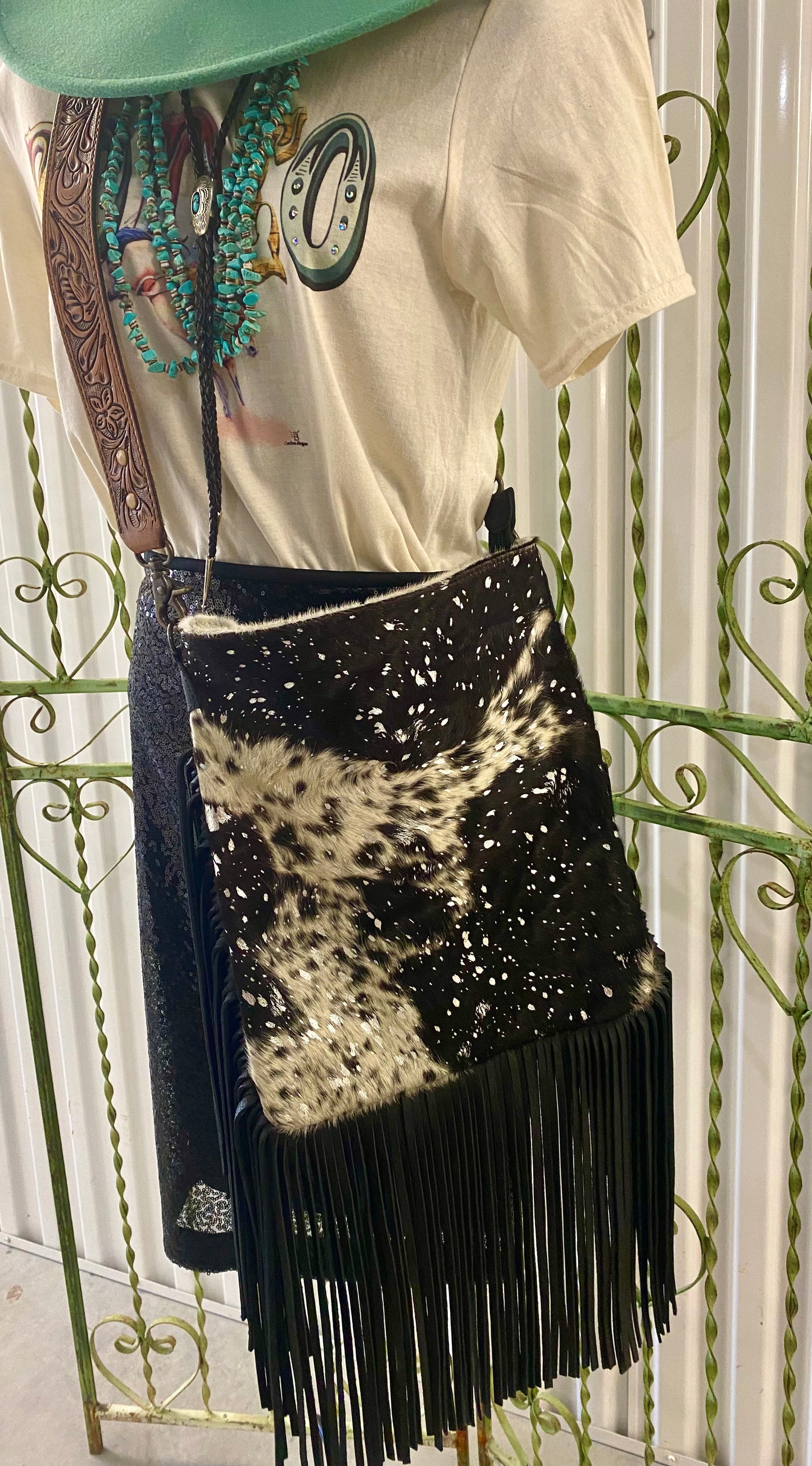 Large Black and White American Darling Western Crossbody Fringe Purse If you like cowhide and fringe and you're looking for a really cute crossbody purse that is also concealed carry, we've got just the purse for you! The Alex crossbody fringe purse is accented with silver metallic spots across the black and white hair on hide cowhide. It also has a removable tooled leather shoulder strap. It features 2 open pockets and 1 zipped pocket inside.