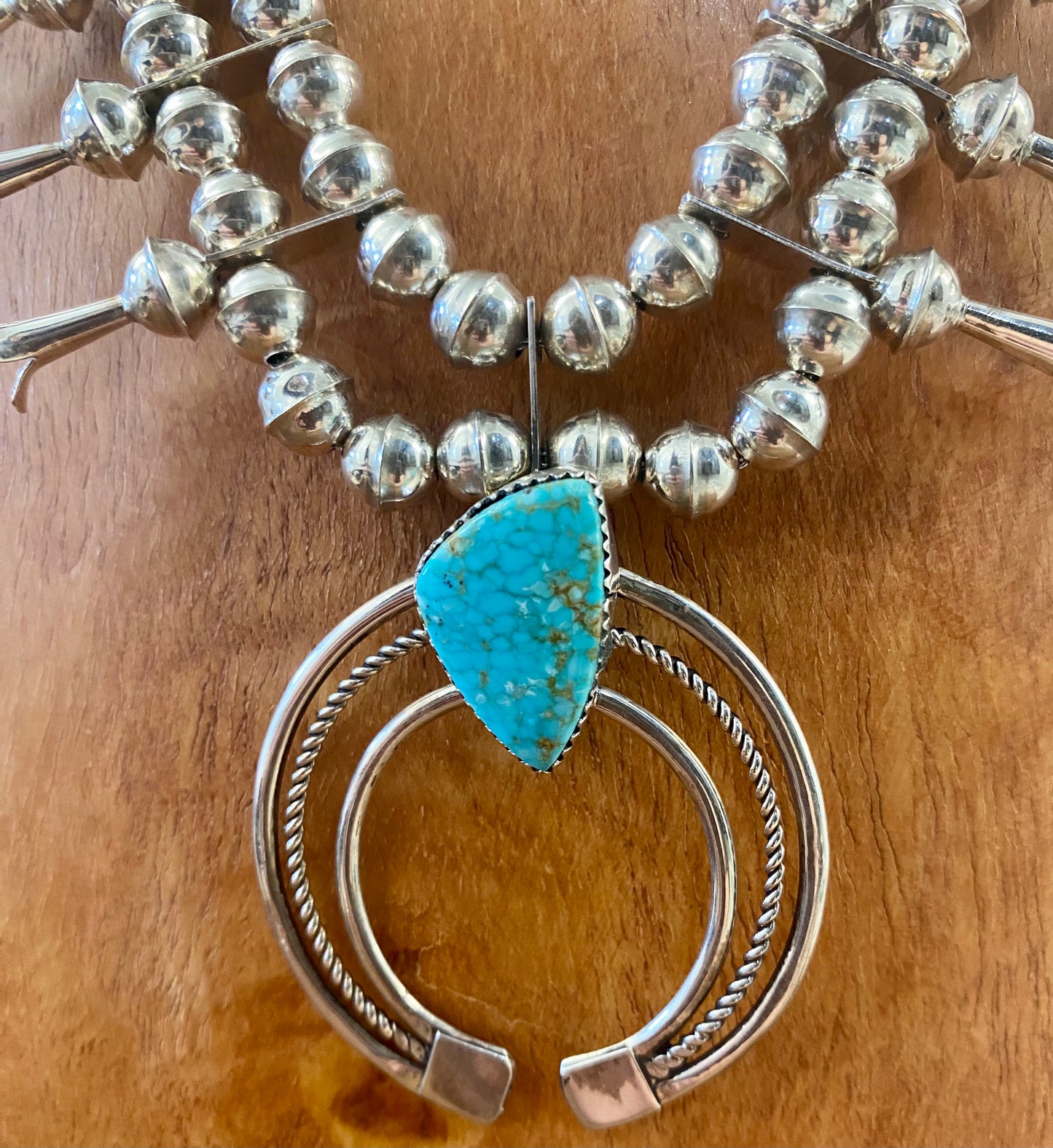 Gorgeous sterling silver handmade Turquoise Squash Blossom necklace stamped STERLING and signed with the initials “PG” on the back of the naja by the artist. A photo of the hallmark will be in the photos above. This necklace will make for a stunning addition to anyone’s jewelry collection. A statement piece for any outfit! The perfect amount of silver and turquoise is handcrafted into this unique piece.