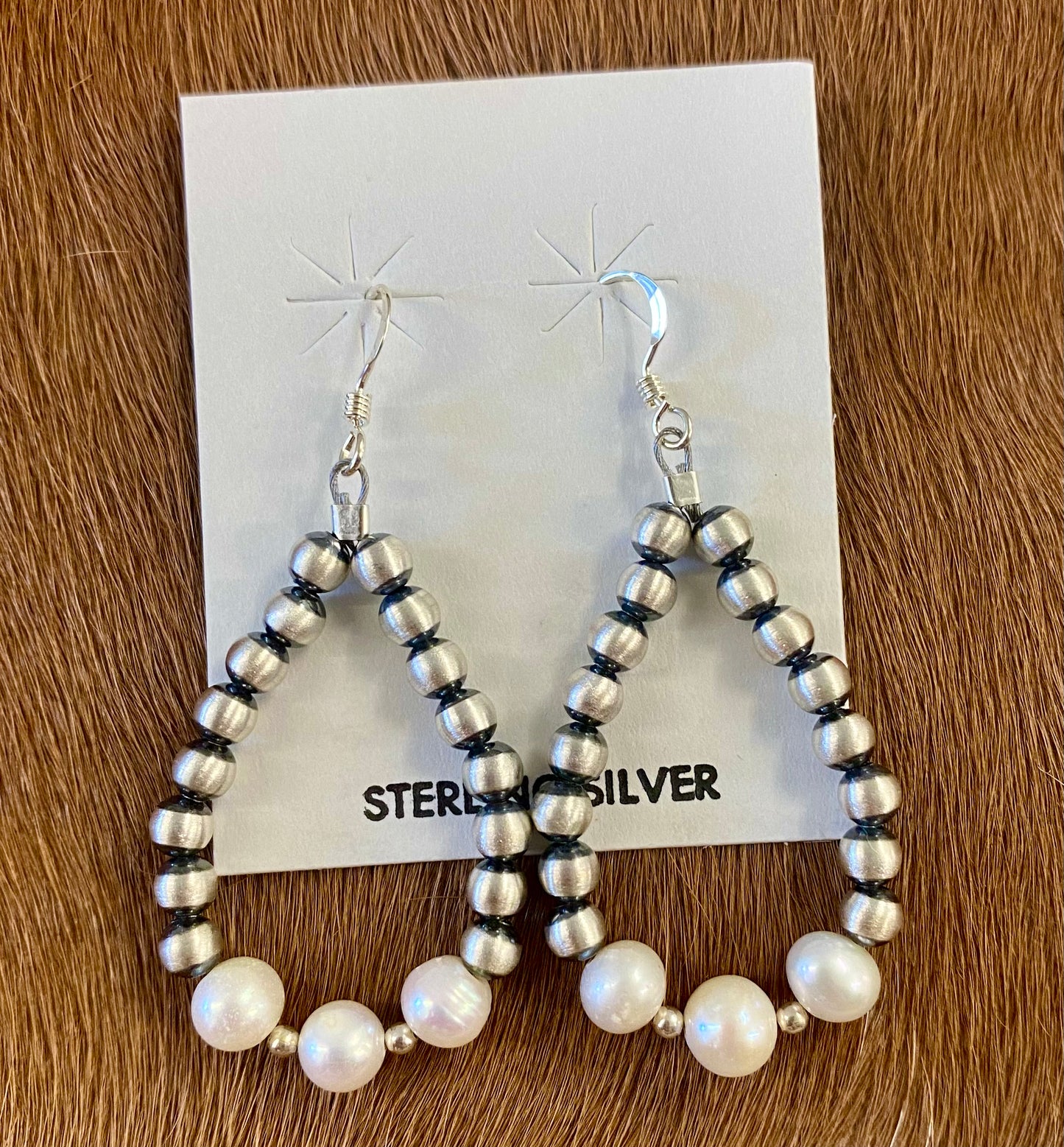 Gorgeous lightweight hand strung navajo pearl teardrop sterling silver earrings with white beads. The perfect earrings to add to anyone's jewelry collection. These Navajo pearl style teardrop earrings are hand strung together. Each of the sterling components are soldered closed to ensure durability and peace of mind. Size: 1.5” inches length x 1” inch width