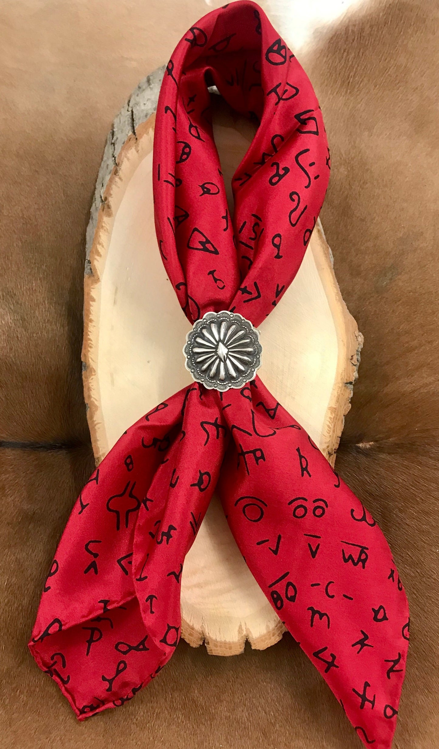 The Red Brand Wild Rag - Ny Texas Style Boutique Black Brands on red background cowboy scarf Wild Rag with hand stitched hem. Perfect for her or him. This can be worn around your neck, in your hair, pocket square, and so many other styles. Gorgeous Silk wild rag featuring various cattle/livestock brands. Also available in a variety of colors on our website. Fabric: 100% Silk Size: 20” X 20” - 20" Square Colors: Red, Black Care Instructions: Hand Wash or Dry Clean - Hang Dry