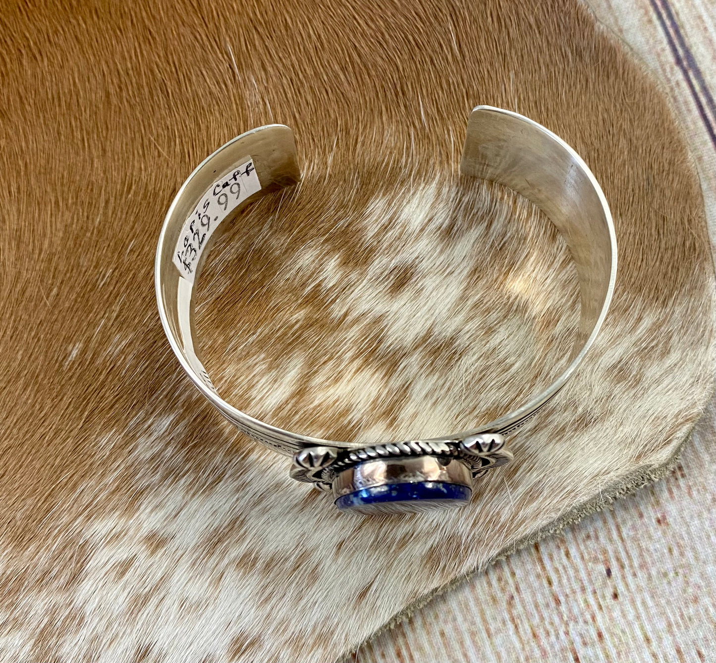 An absolutely stunning large single blue lapis stone with stamped silver detailing down the sides sterling silver cuff bracelet. This is a amazing statement piece that you are sure to receive compliments on! A piece that can be cherished and passed down generations for your children and grandchildren to admire for decades as well as lifetimes to come. Made by the talented Native American artist and silversmith Irene Kee. This beauty is stamped STERLING and signed "I. KEE" inside of the cuff bracelet.