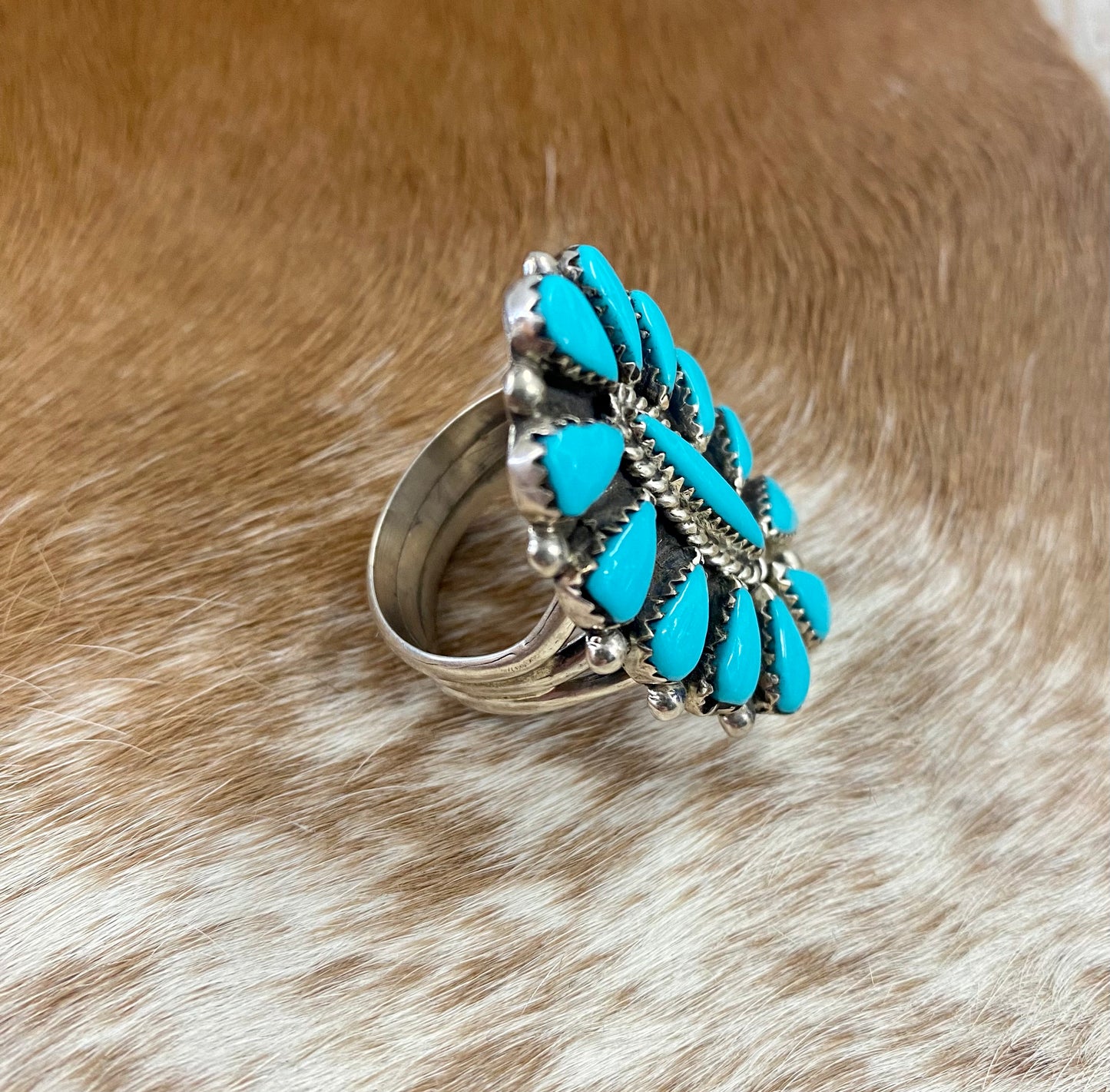 Sleeping Beauty turquoise traditional cluster sterling silver ring. Stamped sterling and signed on the back by a Zuni Native American artist silversmith. Available in size 12 1/2. The perfect piece to add to your accessory wardrobe and jewelry collection.   Size: 1.5 Inches Length X 1” Inch Width    Stone: Sleeping Beauty Turquoise   Signed: YES