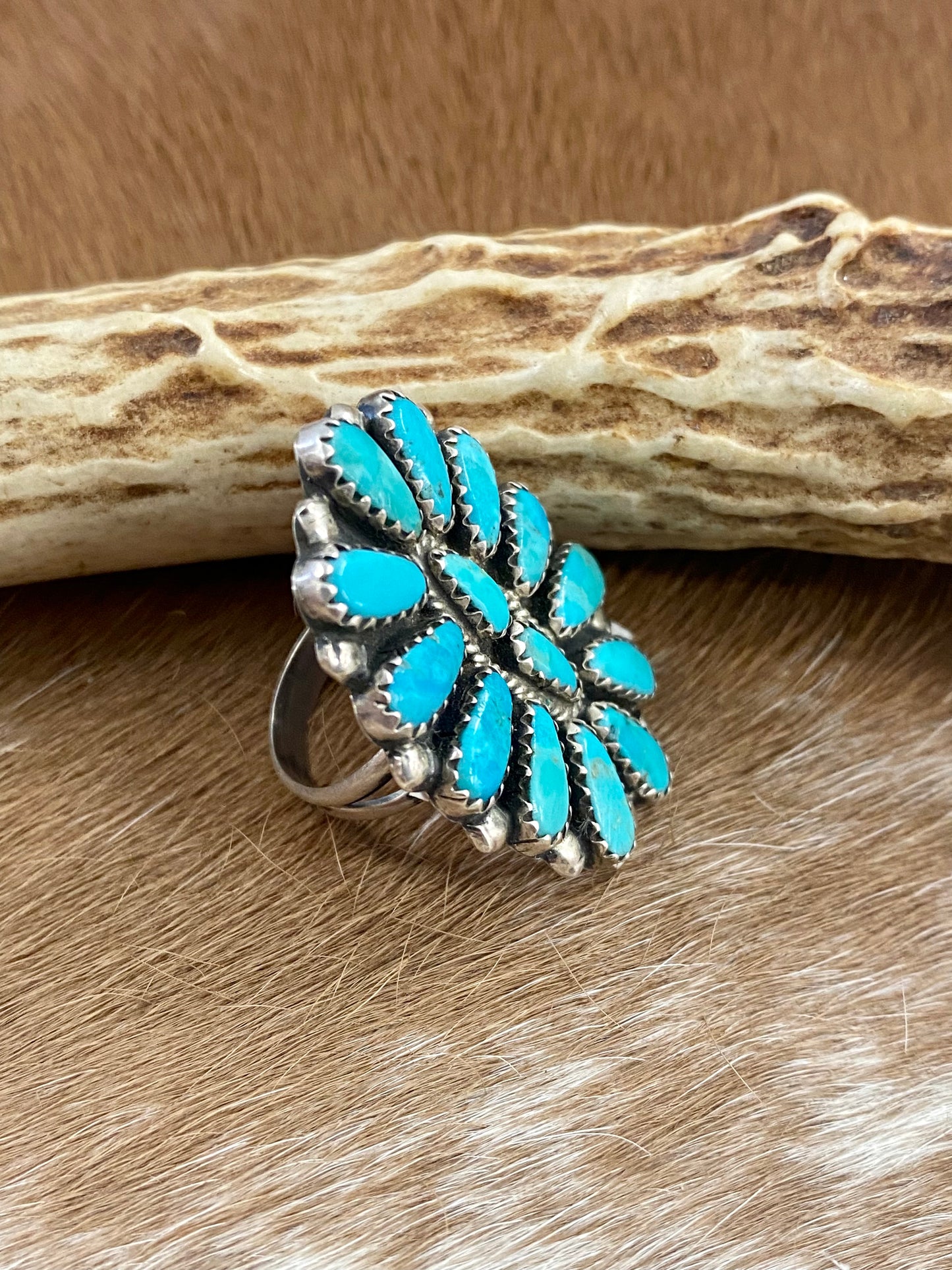 Kingman turquoise traditional cluster sterling silver ring. Stamped sterling and signed “ZB” on the back by artist silversmith Zeita Begay. Available in size 4 1/2. The perfect piece to add to your accessory wardrobe and jewelry collection. Size: 1.5 Inches Length X 1” Inch Width Stone: Kingman Turquoise Signed: YES “ZB” Hallmark: Zeita Begay
