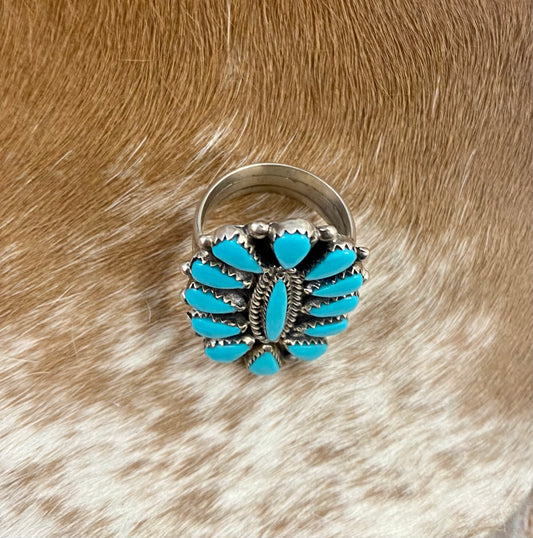 Sleeping Beauty turquoise traditional cluster sterling silver ring. Stamped sterling and signed on the back by a Zuni Native American artist silversmith. Available in size 12 1/2. The perfect piece to add to your accessory wardrobe and jewelry collection.   Size: 1.5 Inches Length X 1” Inch Width    Stone: Sleeping Beauty Turquoise   Signed: YES