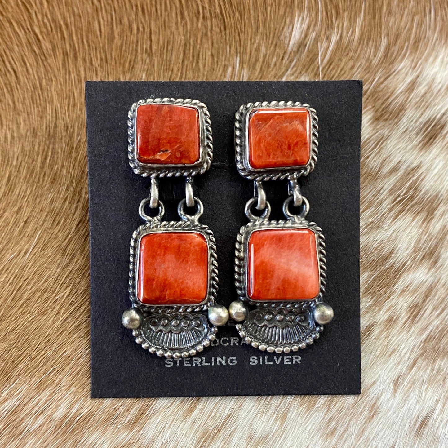 The O.A. Spiny Oyster Earrings - Ny Texas Style Boutique Sterling Silver Spiny Oyster Post Native American Made By Oscar AlexiusRed orange Spiny Oyster post sterling silver earrings. Stamped sterling and signed by Native American artist silversmith Oscar Alexius on the back. The perfect pop of color for any outfit! Size: 1.25” Inches Length Stone: Spiny Oyster Singed: YES "O.A." Hallmark/Artist: Oscar Alexius