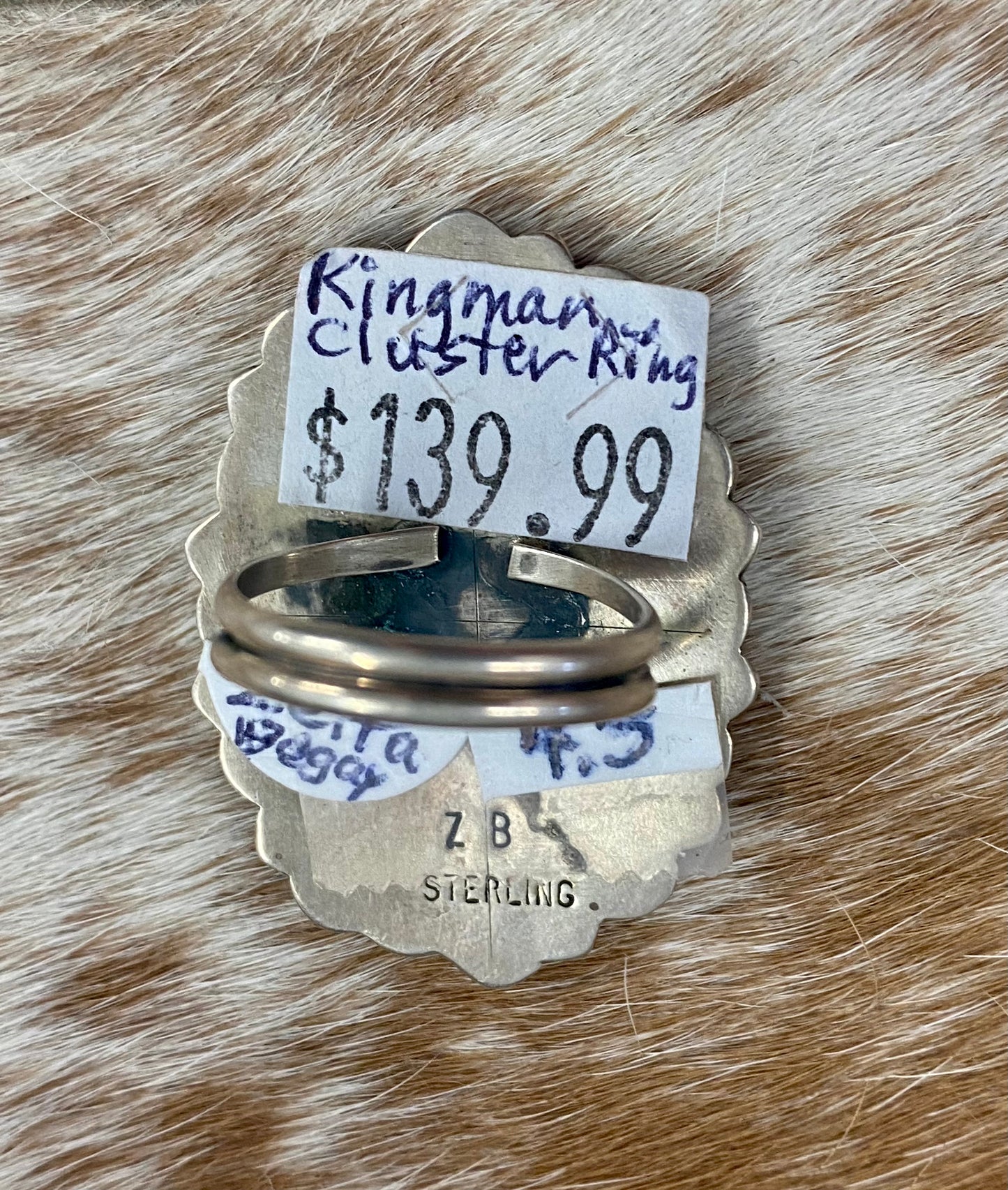 Kingman turquoise traditional cluster sterling silver ring. Stamped sterling and signed “ZB” on the back by artist silversmith Zeita Begay. Available in size 4 1/2. The perfect piece to add to your accessory wardrobe and jewelry collection. Size: 1.5 Inches Length X 1” Inch Width Stone: Kingman Turquoise Signed: YES “ZB” Hallmark: Zeita Begay