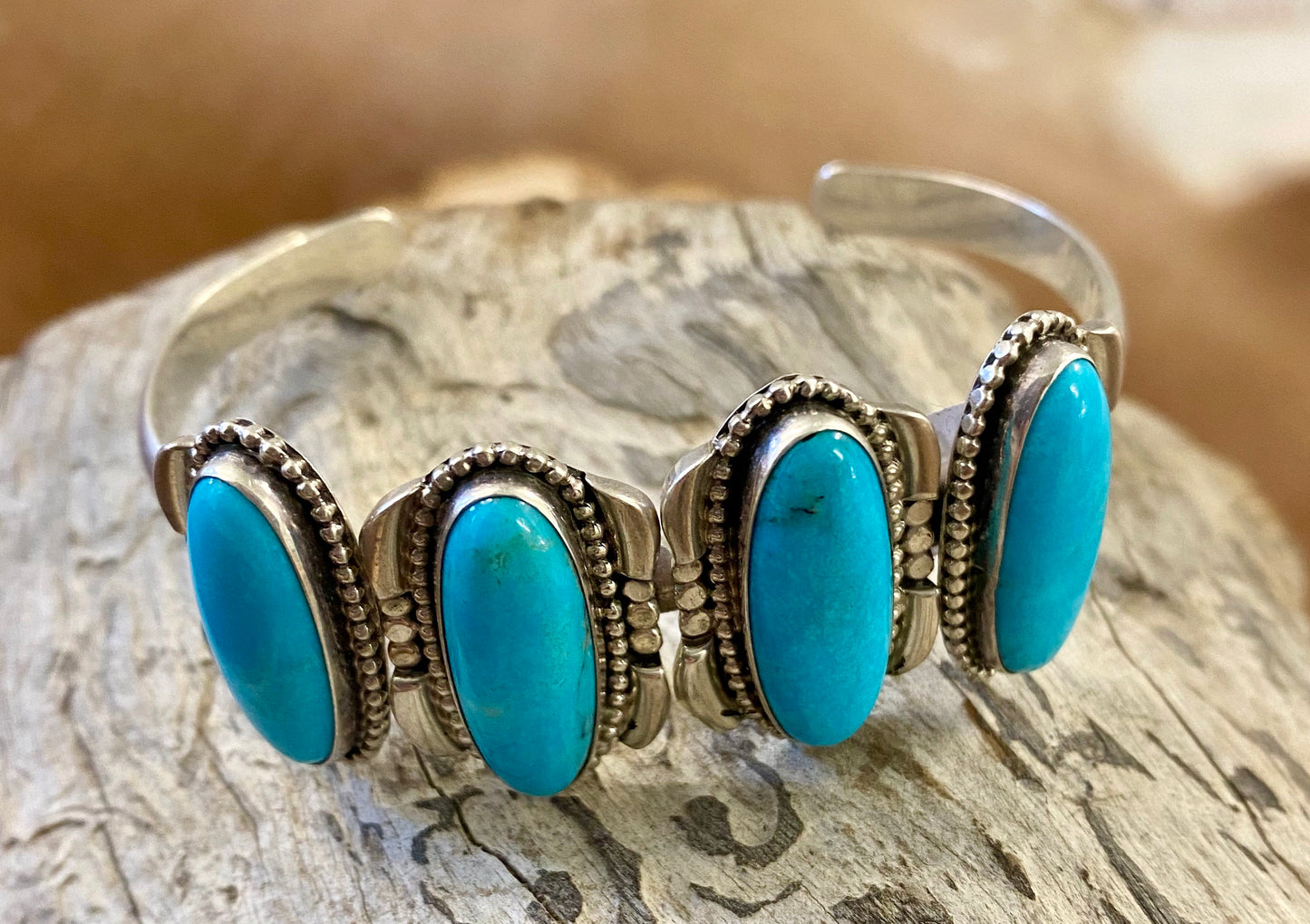 Silver four stone Native American made turquoise stamped sterling and signed cuff. This cuff is absolutely stunning and the perfect piece for your jewelry collection or give as a gift to a loved one. Stamped Sterling & Signed R.B. Inside of a bear icon for Running Bear Shop on the inside of the cuff. Size: Stones are 1” length 6.5” all the way around not including gap Stone: Turquoise Signed: YES "R.B." Inside of a bear icon Hallmark/Artist: Running Bear Shop