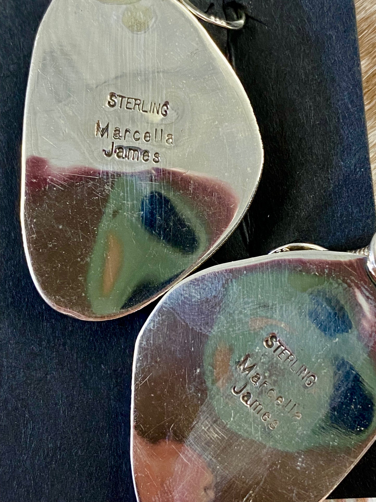 Stunning large statement hook sterling silver white buffalo native made earrings. Stamped sterling and signed by Native American artist silversmith Marcella James. These will make for a beautiful addition to anyone's jewelry collection. Size: 1.5 inches length x 1” inches width Signed: YES "MARCELLA JAMES" Hallmark/Artist: MARCELLA JAMES Stone: White Buffalo