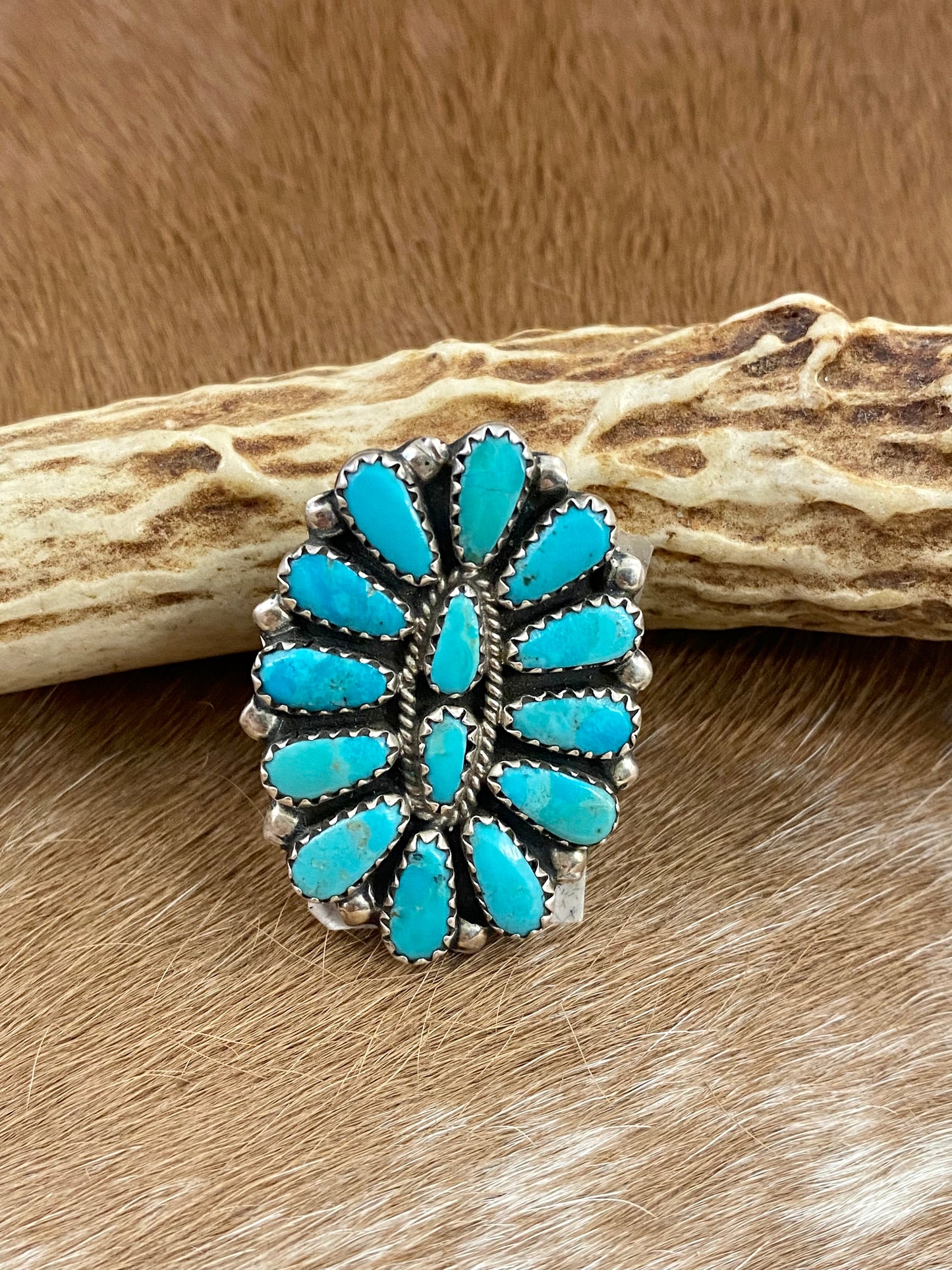 Kingman turquoise traditional cluster sterling silver ring. Stamped sterling and signed “ZB” on the back by artist silversmith Zeita Begay. Available in size 4 1/2. The perfect piece to add to your accessory wardrobe and jewelry collection. Size: 1.5 Inches Length X 1” Inch Width Stone: Kingman Turquoise Signed: YES “ZB” Hallmark: Zeita Begay