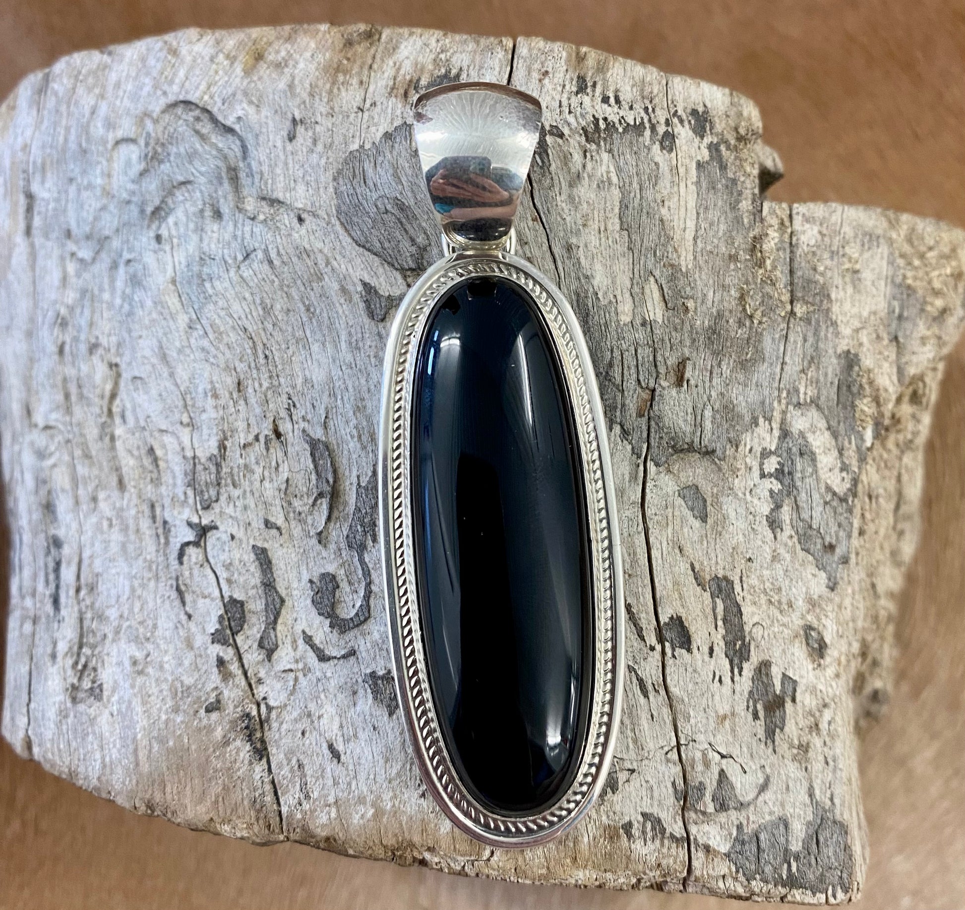 The perfect single-stone sterling silver Native American-made large black onyx pendant to add to any necklace. This piece will look gorgeous on a strand of Navajo pearls or a chain necklace. Stamped sterling and signed Harley Jake by Native artist silversmith Harley Jake on the back of the pendant.   Size: 2” inch length, bale 1/2” inch. 1" inch width   Signed: YES "Harley Jake"   Hallmark/ Artist: Harley Jake  Stone: Onyx