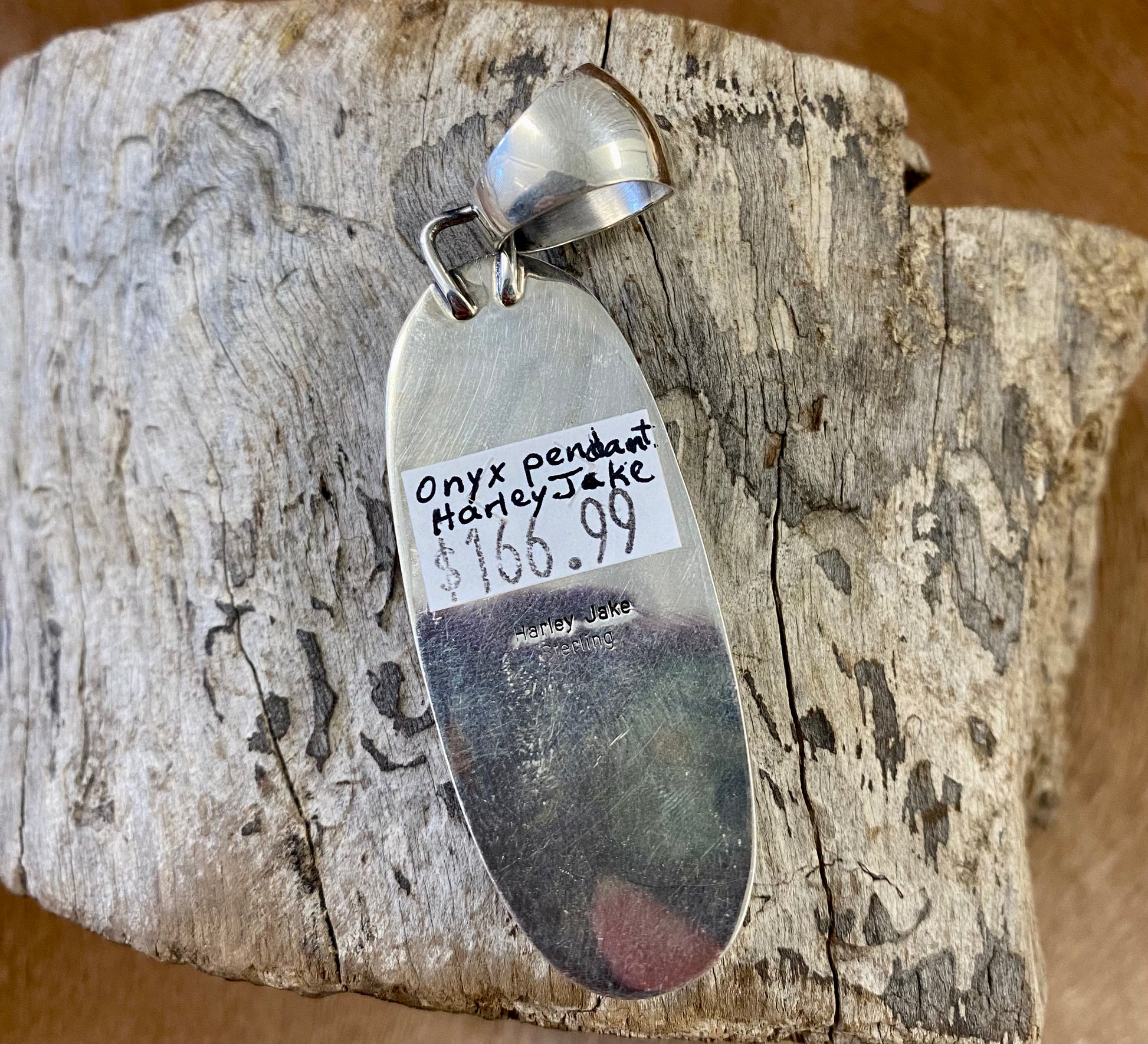 The perfect single-stone sterling silver Native American-made large black onyx pendant to add to any necklace. This piece will look gorgeous on a strand of Navajo pearls or a chain necklace. Stamped sterling and signed Harley Jake by Native artist silversmith Harley Jake on the back of the pendant.   Size: 2” inch length, bale 1/2” inch. 1" inch width   Signed: YES "Harley Jake"   Hallmark/ Artist: Harley Jake  Stone: Onyx