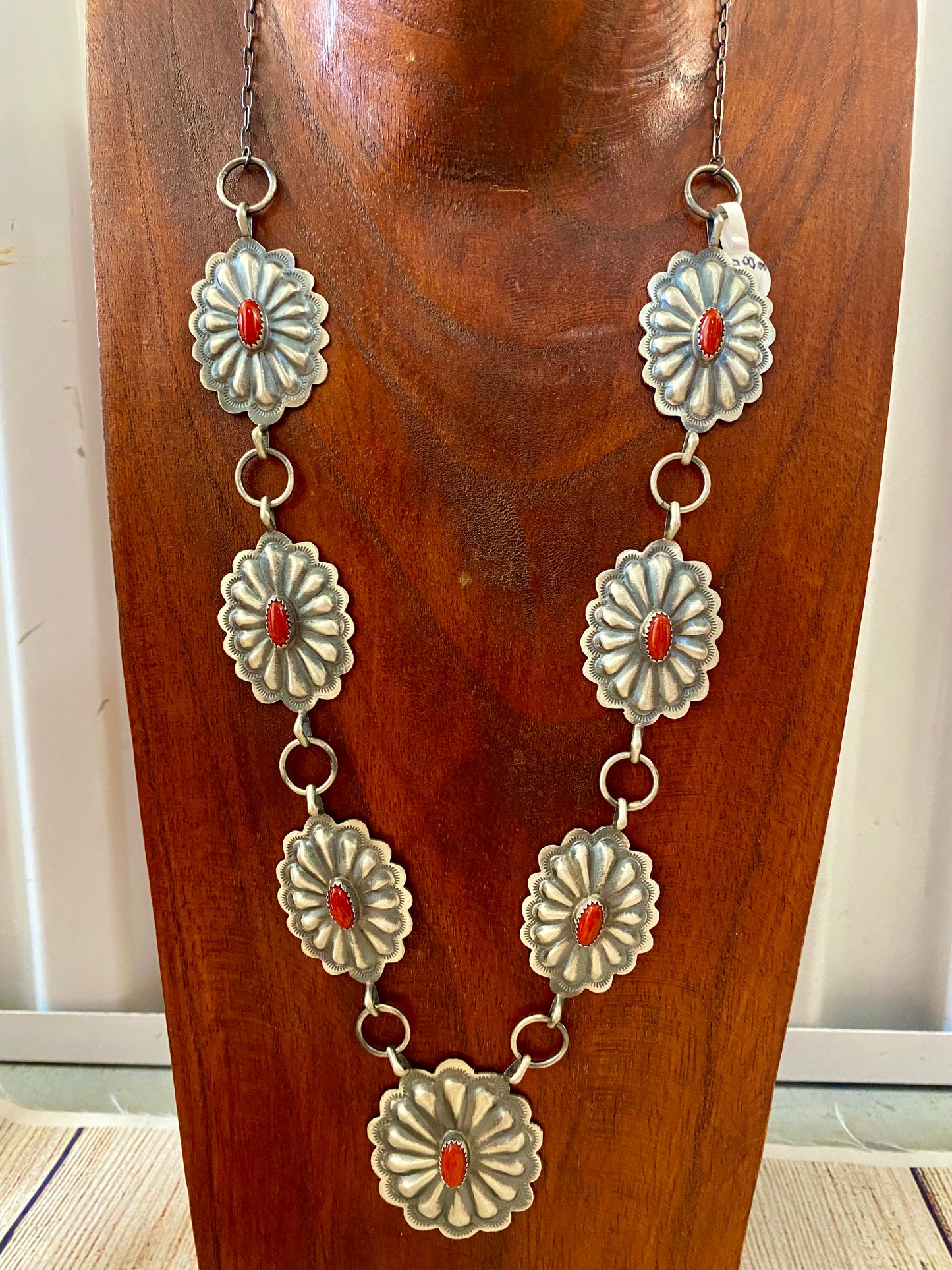 Beautiful seven silver and coral concho long 30" inch length sterling silver Native American made necklace. The piece is stamped sterling and signed "DM" on the back of the necklace. Size: 30" Inches length Stone: Coral Signed: YES "DM" Handmade Concho Coral Sterling Silver Native American Made Necklace