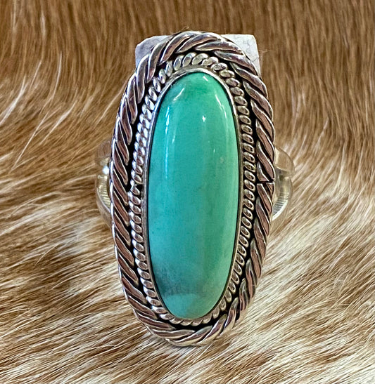 Beautiful simple and elegant Native made sterling silver single stone turquoise ring. Stamped .925 and signed "R.B." inside of a bear icon for Running Bear Shop. The perfect everyday turquoise ring! Size: 1.25” inches length x .5” inch width Ring Size: 7 Signed: YES "R.B." Hallmark/Artist: Running Bear Shop Stone: Turquoise