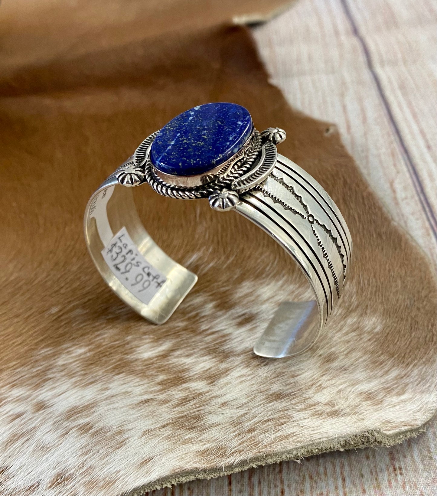 An absolutely stunning large single blue lapis stone with stamped silver detailing down the sides sterling silver cuff bracelet. This is a amazing statement piece that you are sure to receive compliments on! A piece that can be cherished and passed down generations for your children and grandchildren to admire for decades as well as lifetimes to come. Made by the talented Native American artist and silversmith Irene Kee. This beauty is stamped STERLING and signed "I. KEE" inside of the cuff bracelet.