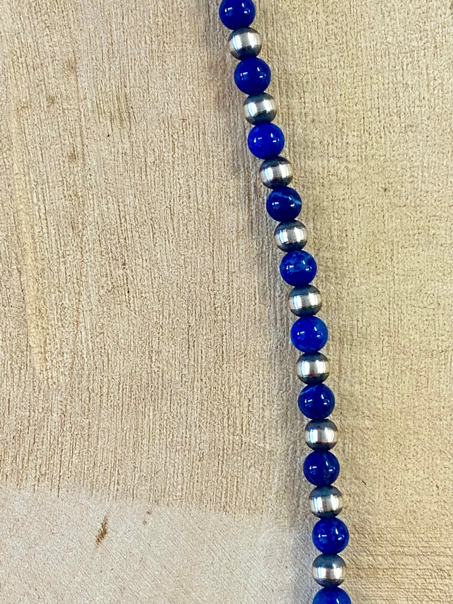 Sterling silver single strand Native American made hand strung Lapis and Navajo Pearl 20” inch length necklace. The perfect necklace to wear alone, layered with other necklaces, or with a pendant! This necklace is stamped .925 on a small pendant on the hook clasp. Size: 20" Inches Length Stone: Lapis and Navajo Pearl Signed: YES ".925"
