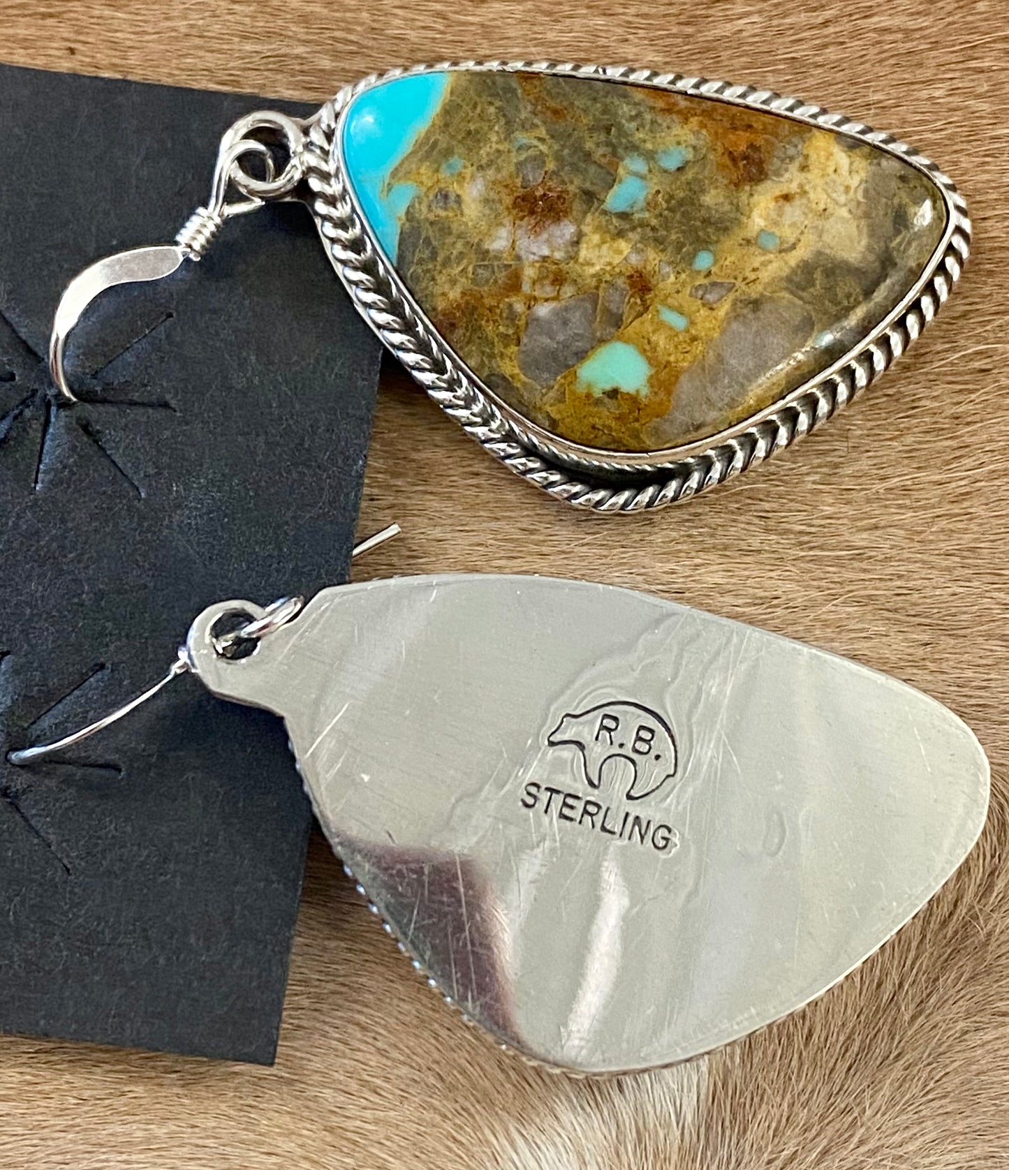 Absolutely stunning large single stone hook turquoise sterling silver Native American made earrings. The perfect statement or everyday earrings to add to your jewelry collection. These are stamped sterling and signed by Running Bear Shop. native artist and silversmith Rosie Chee made. Signed: YES "R.B." Running Bear Shop Hallmark/ Artist: Rosie Chee Size: 1” inch length Strone: Turquoise