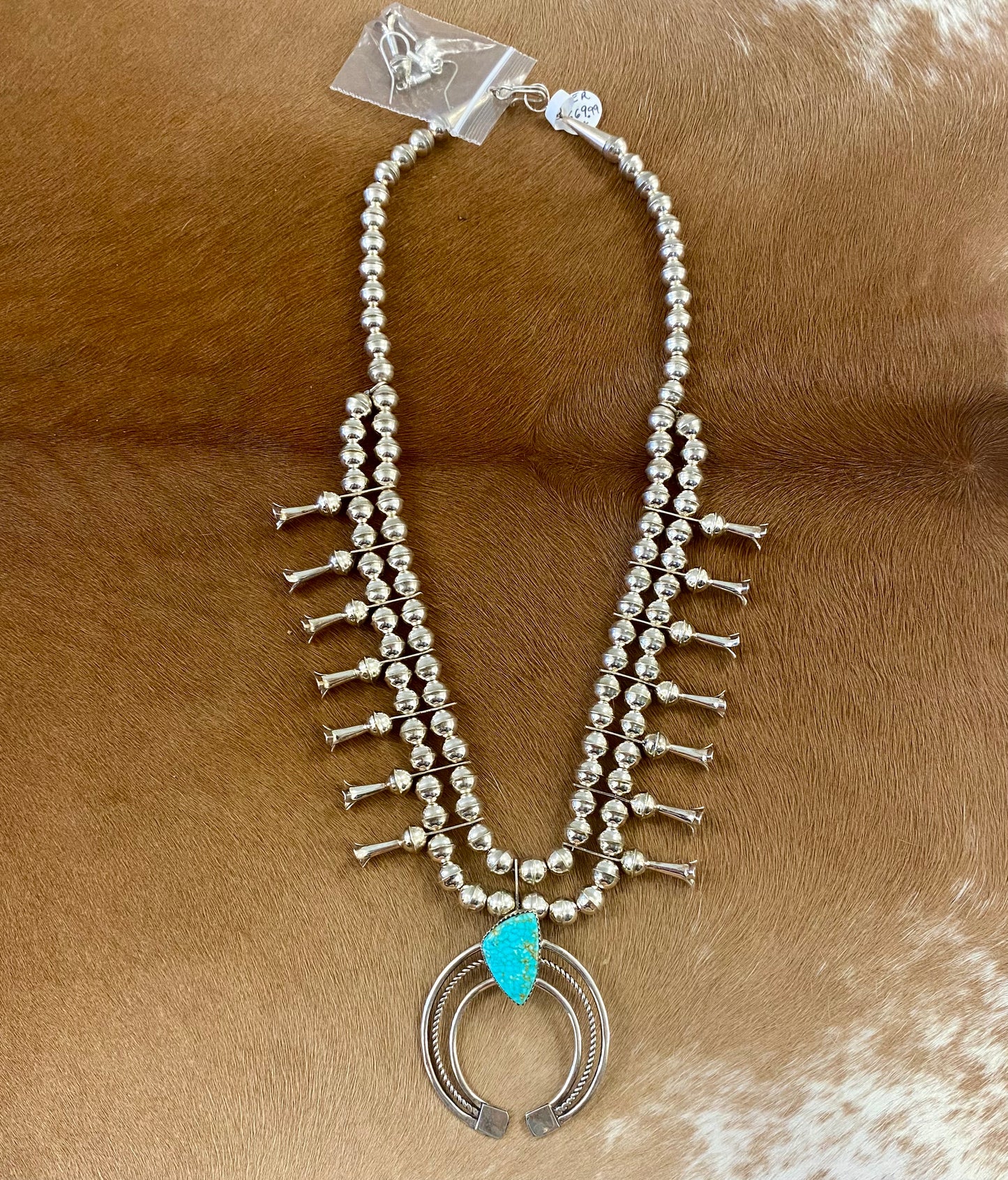 Gorgeous sterling silver handmade Turquoise Squash Blossom necklace stamped STERLING and signed with the initials “PG” on the back of the naja by the artist. A photo of the hallmark will be in the photos above. This necklace will make for a stunning addition to anyone’s jewelry collection. A statement piece for any outfit! The perfect amount of silver and turquoise is handcrafted into this unique piece.