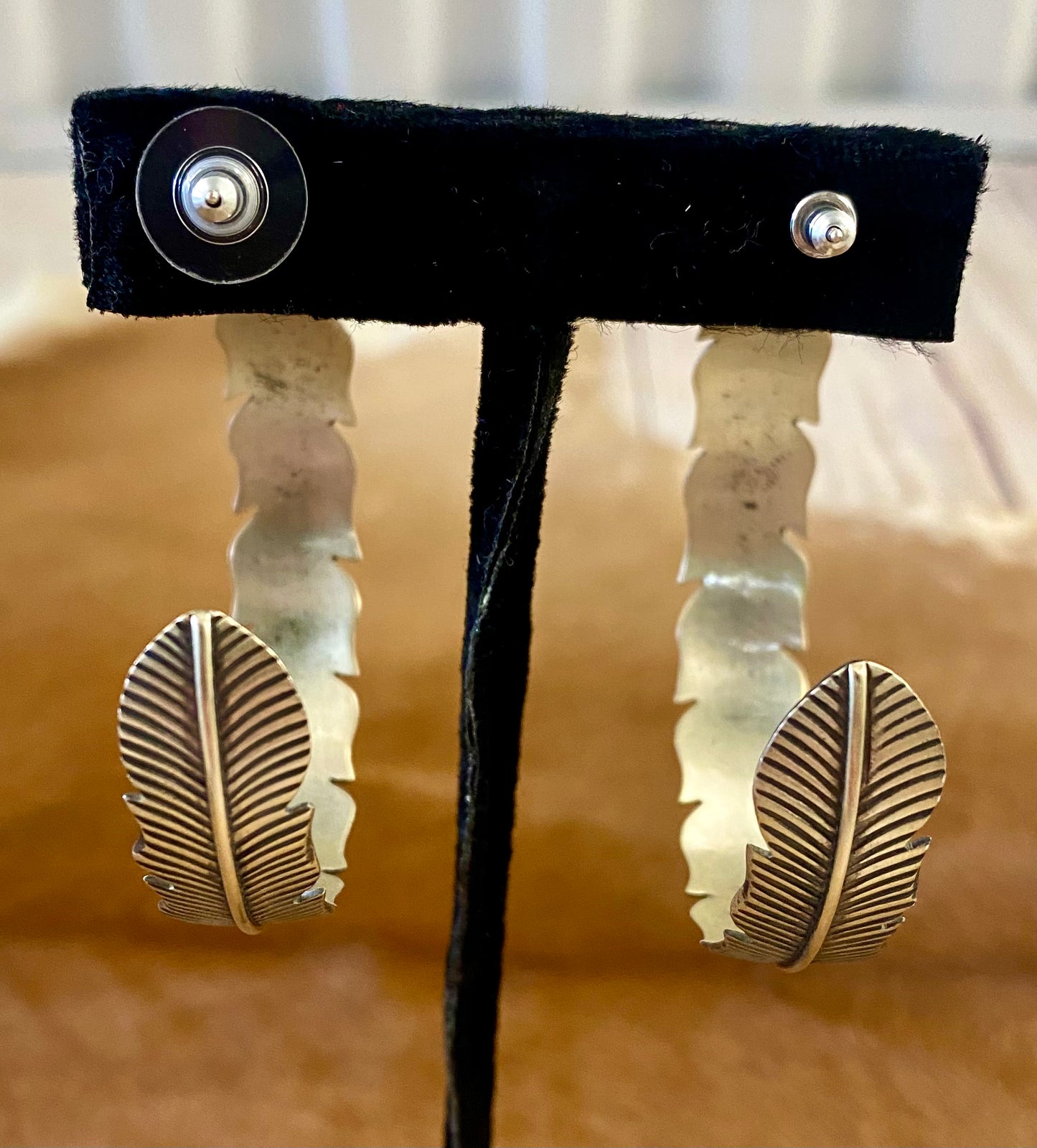 The Feather Indians Silver Earrings Stunning and unique sterling silver large feather post half hoop Native American handmade earrings. Very easy to dress up or down depending on the outfit! Add these beauties to you or your loved ones jewelry collection TODAY!   Size: 2” inch long