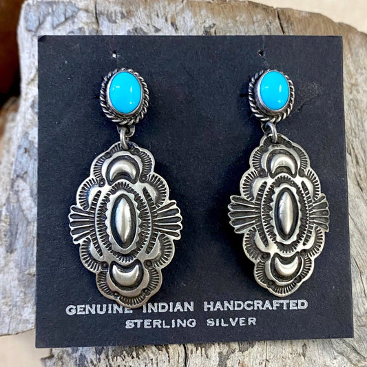 The D. Cadman Turquoise Earrings - Ny Texas Style Boutique Turquoise post sterling silver dangle statement earrings, signed and made by Native American artist silversmith Darrell Cadman. These beauties are Native made stamped sterling and signed "D. Cadman" on the back. Size: 1.75” Inches length Stone: Turquoise Signed: YES "D. Cadman" Artist/Hallmark: Darrell Cadman