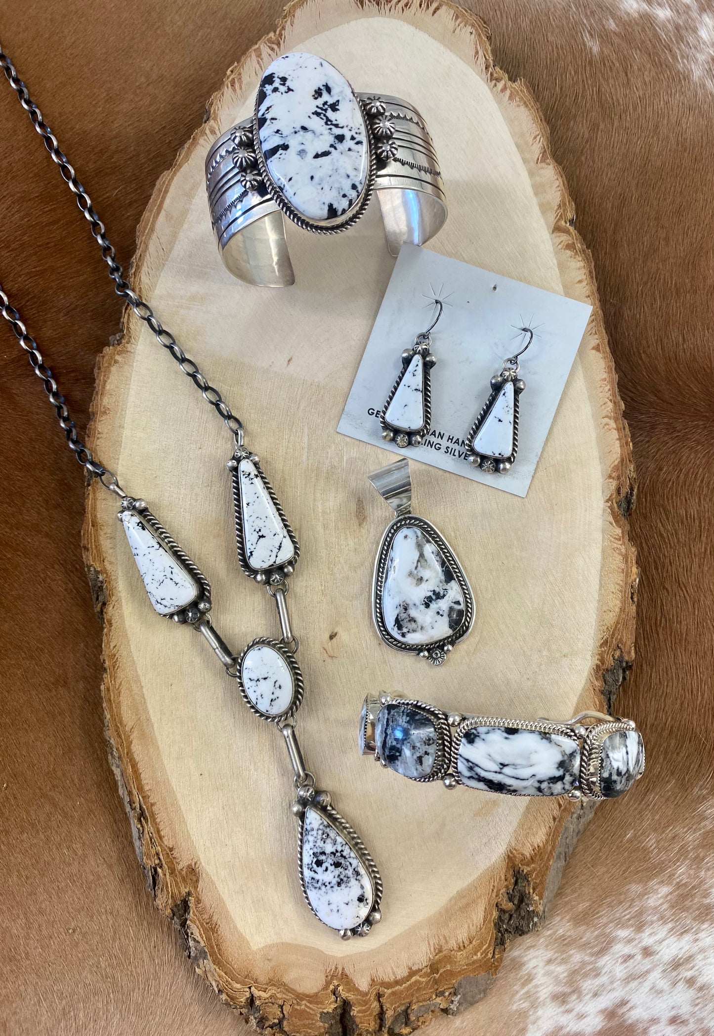 Stunning White Buffalo lariat style sterling silver Native American made necklace and drop hook matching White Buffalo sterling silver earrings set. The perfect jewelry set to gift to your loved one or keep for your own jewelry collection! Both pieces are stamped sterling and signed on the back by talented artist silversmith Annie Spencer. Size: 27” inches in length necklace + 1 1/2” inch earrings Stone: White Buffalo Signed: YES "AL" Artist / Hallmark: Annie Spencer