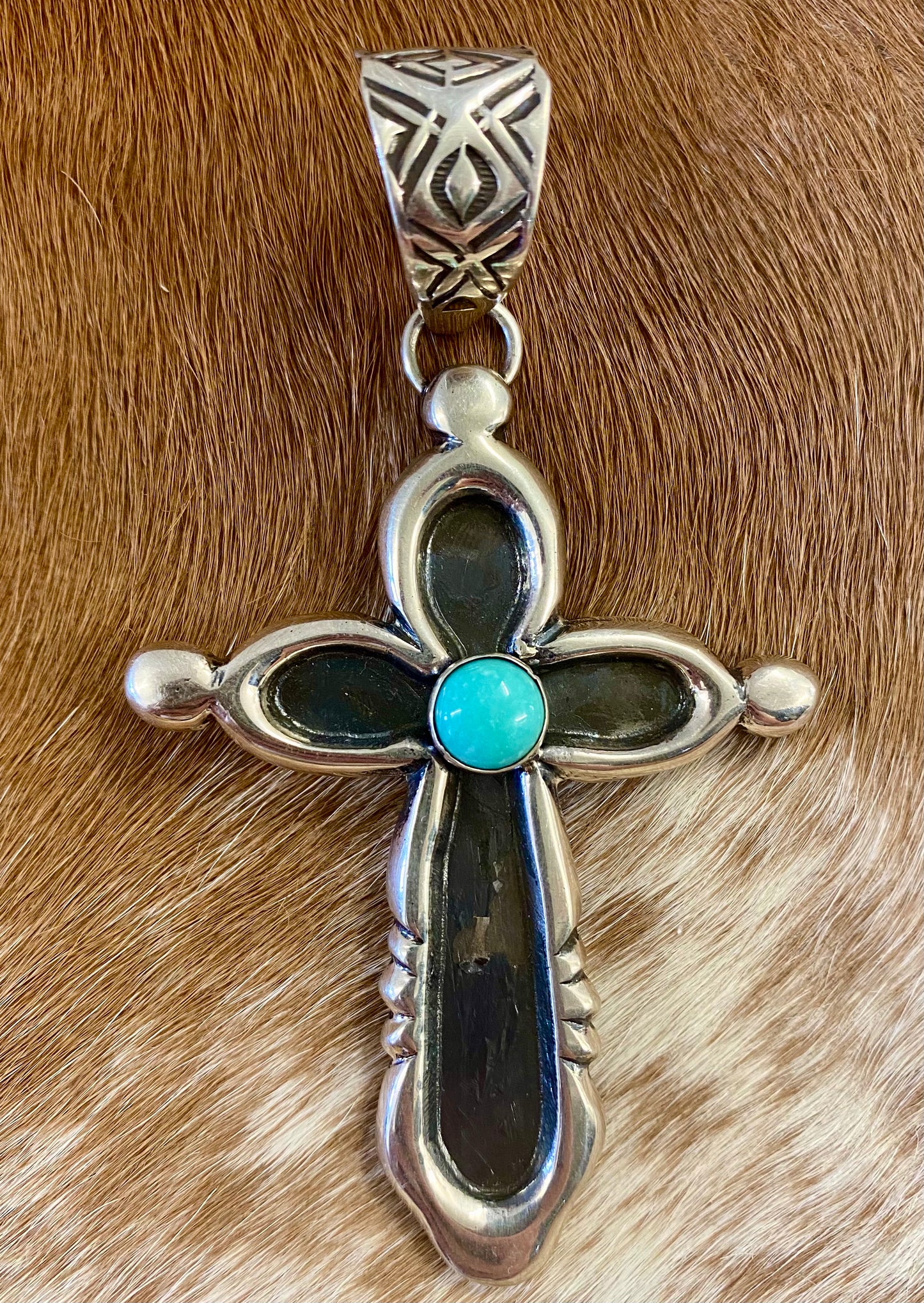 Beautiful sterling silver Native made turquoise cross pendant. Stamped sterling and signed H. JOE by Native American artist silversmith. The perfect cross to wear on any length chain necklace or a 6-7mm Navajo pearl necklace. Size: 3” Inches length without bale x 2” inches width - bale .5” inch length Signed: YES "H. JOE" Hallmark/Artist: H. JOE Stone: Turquoise