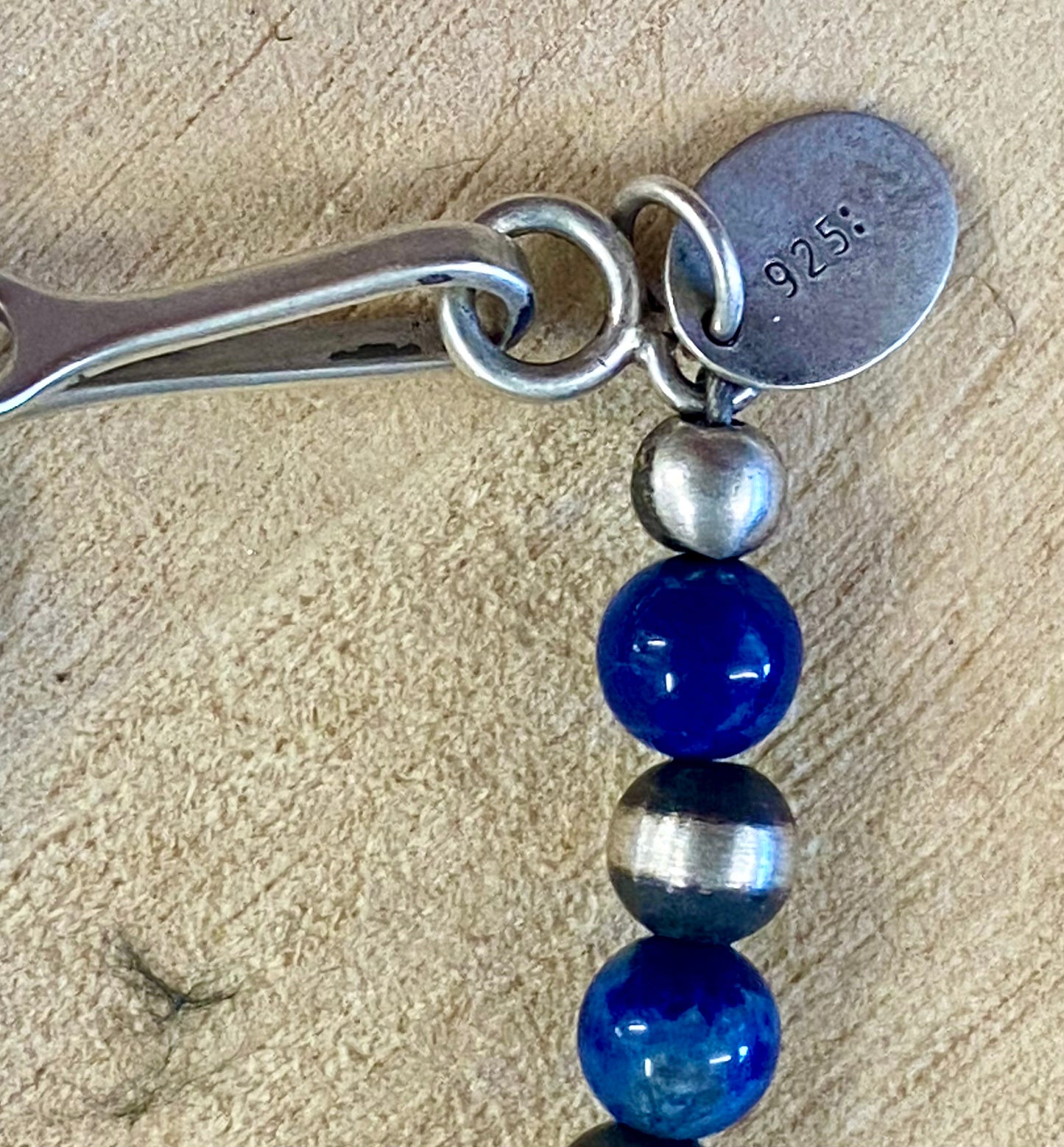 Sterling silver single strand Native American made hand strung Lapis and Navajo Pearl 20” inch length necklace. The perfect necklace to wear alone, layered with other necklaces, or with a pendant! This necklace is stamped .925 on a small pendant on the hook clasp. Size: 20" Inches Length Stone: Lapis and Navajo Pearl Signed: YES ".925"