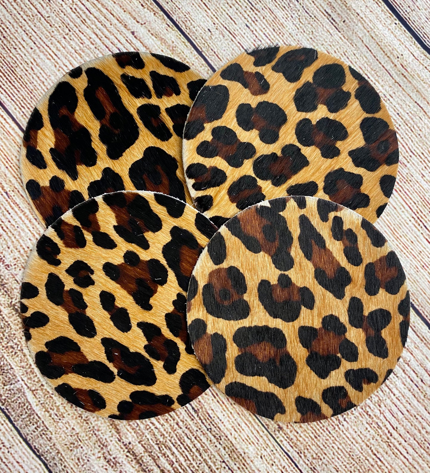 A beautiful set of leopard print cowhide coasters that will look great on any table, counter or shelf. Each one is made from natural cowhide leather, meaning they are durable, able to absorb moisture and easy to clean. These beautiful hair-on-hide rustic leather coasters are great gifts for weddings, showers, birthdays, holidays or any other special occasion. They protect your furniture while also adding a little western touch to the room. Perfect for your living spaces and offices.