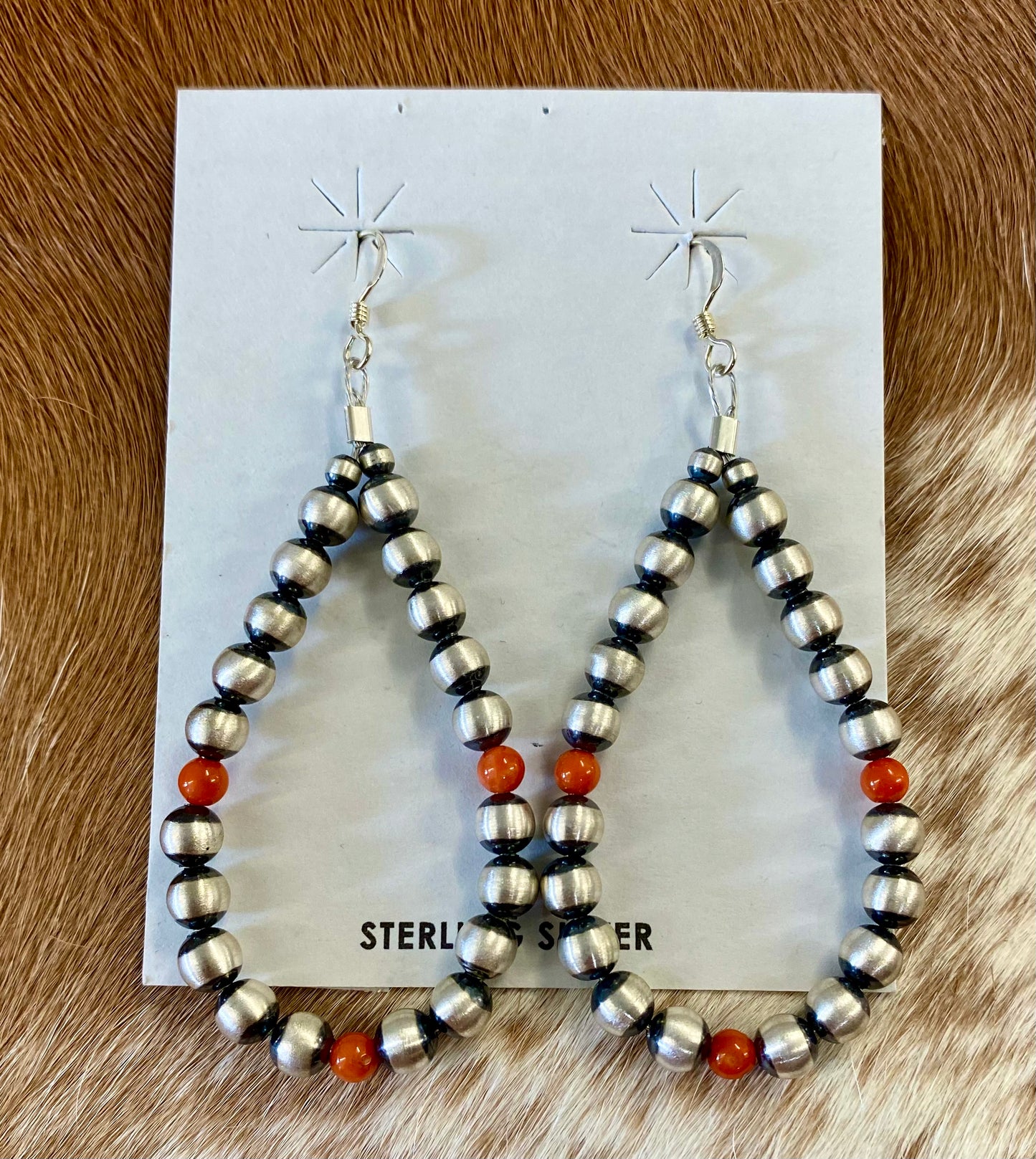 Stunning hook lightweight orange coral native hand strung sterling silver teardrop earrings. The perfect earrings for the fall weather headed our way! The perfect earrings to add to your jewelry collection or gift to a loved one. These Navajo pearl style teardrop earrings are hand strung together. Each of the sterling components are soldered closed to ensure durability and peace of mind. Size: 2.5” Inches length x 1.25” inches width Stone: Coral