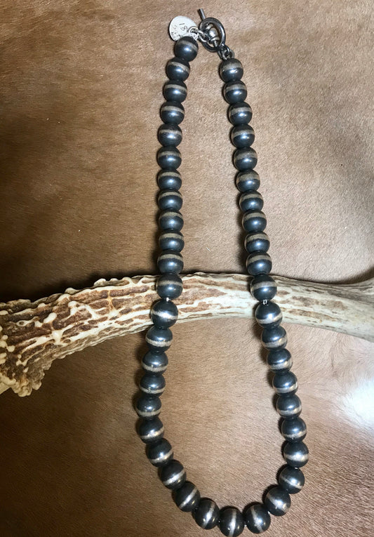 The Dwight 8mm Navajo Pearl Necklace - Ny Texas Style Boutique This authentic hand strung Navajo Pearl sterling silver necklace is a beauty. A stunning single strand sterling silver Navajo Pearl beaded silver necklace. Simple minimalist design. Layer it or wear it alone or even add a pendant to keep your look totally unique. The perfect dainty layering piece! Simple, yet striking! Size: 10mm Navajo Pearls Length: 18.5" Inches