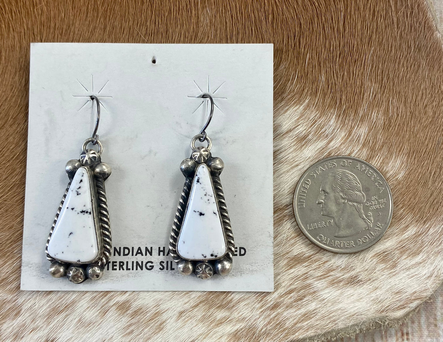 Stunning White Buffalo lariat style sterling silver Native American made necklace and drop hook matching White Buffalo sterling silver earrings set. The perfect jewelry set to gift to your loved one or keep for your own jewelry collection! Both pieces are stamped sterling and signed on the back by talented artist silversmith Annie Spencer. Size: 27” inches in length necklace + 1 1/2” inch earrings Stone: White Buffalo Signed: YES "AL" Artist / Hallmark: Annie Spencer
