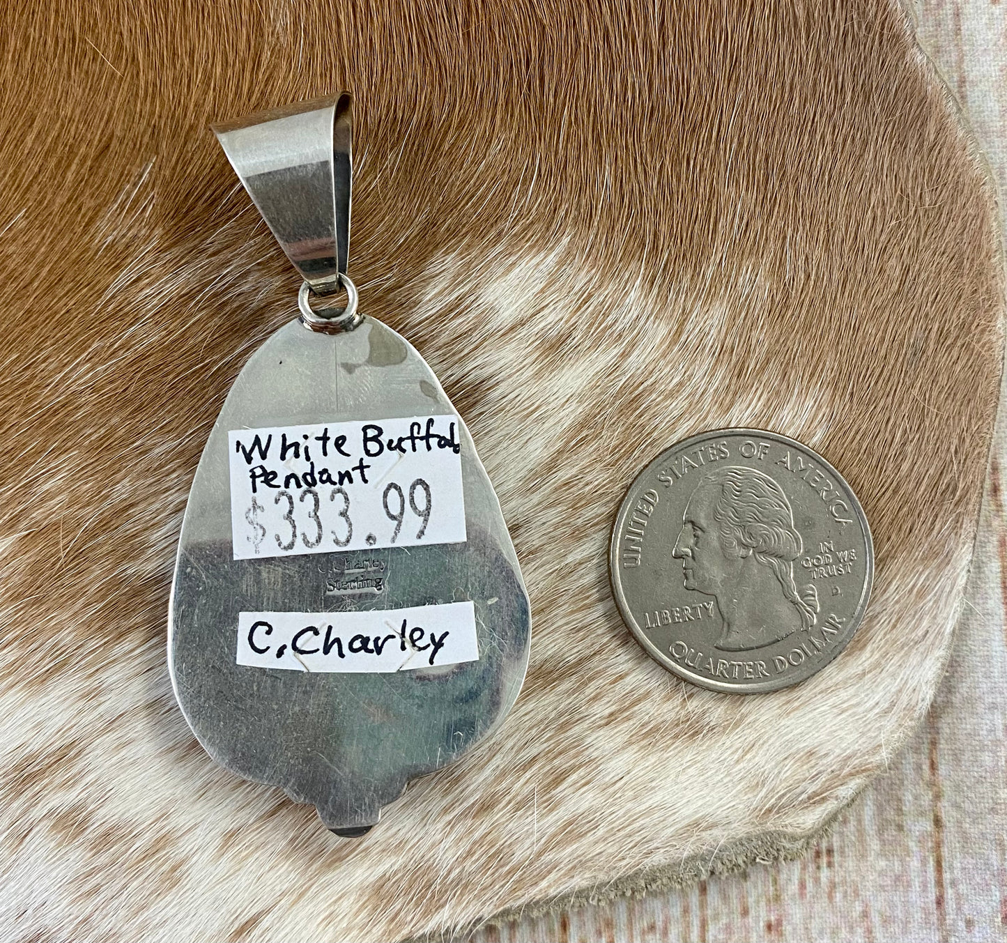 The perfect single-stone sterling silver unique Native American-made large White Buffalo pendant to add to any necklace. This piece will look gorgeous on a strand of Navajo pearls or a chain necklace. Stamped sterling and signed C Charley by Native artist silversmith. The perfect piece to add to your next outfit!   Size: 1 3/4” inches in length without bale, bale 1/2” inch. 1 1/4" inches in width   Signed: YES "C. Charley"   Hallmark/ Artist: C. Charley Stone: White Buffalo