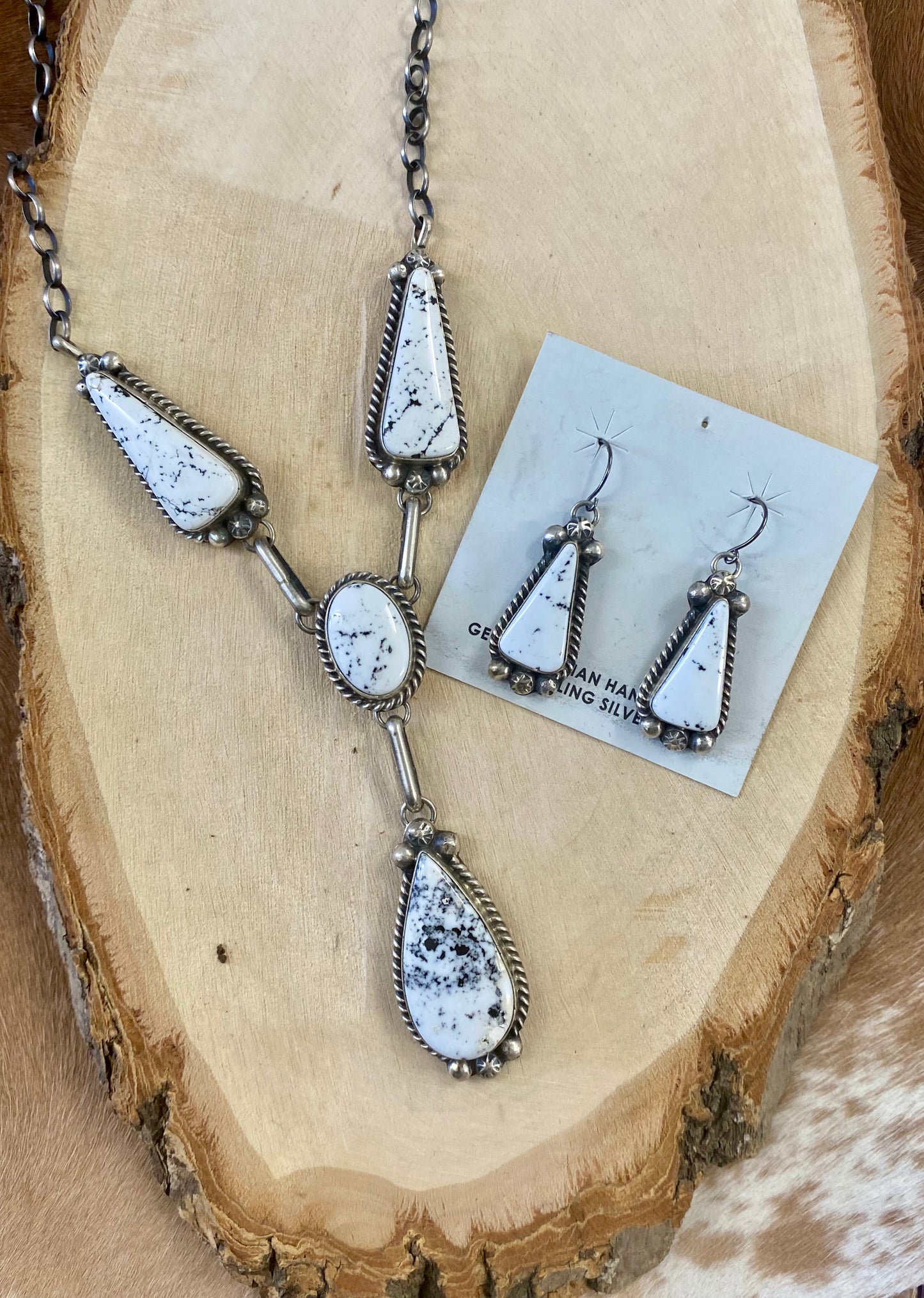Stunning White Buffalo lariat style sterling silver Native American made necklace and drop hook matching White Buffalo sterling silver earrings set. The perfect jewelry set to gift to your loved one or keep for your own jewelry collection! Both pieces are stamped sterling and signed on the back by talented artist silversmith Annie Spencer. Size: 27” inches in length necklace + 1 1/2” inch earrings Stone: White Buffalo Signed: YES "AL" Artist / Hallmark: Annie Spencer