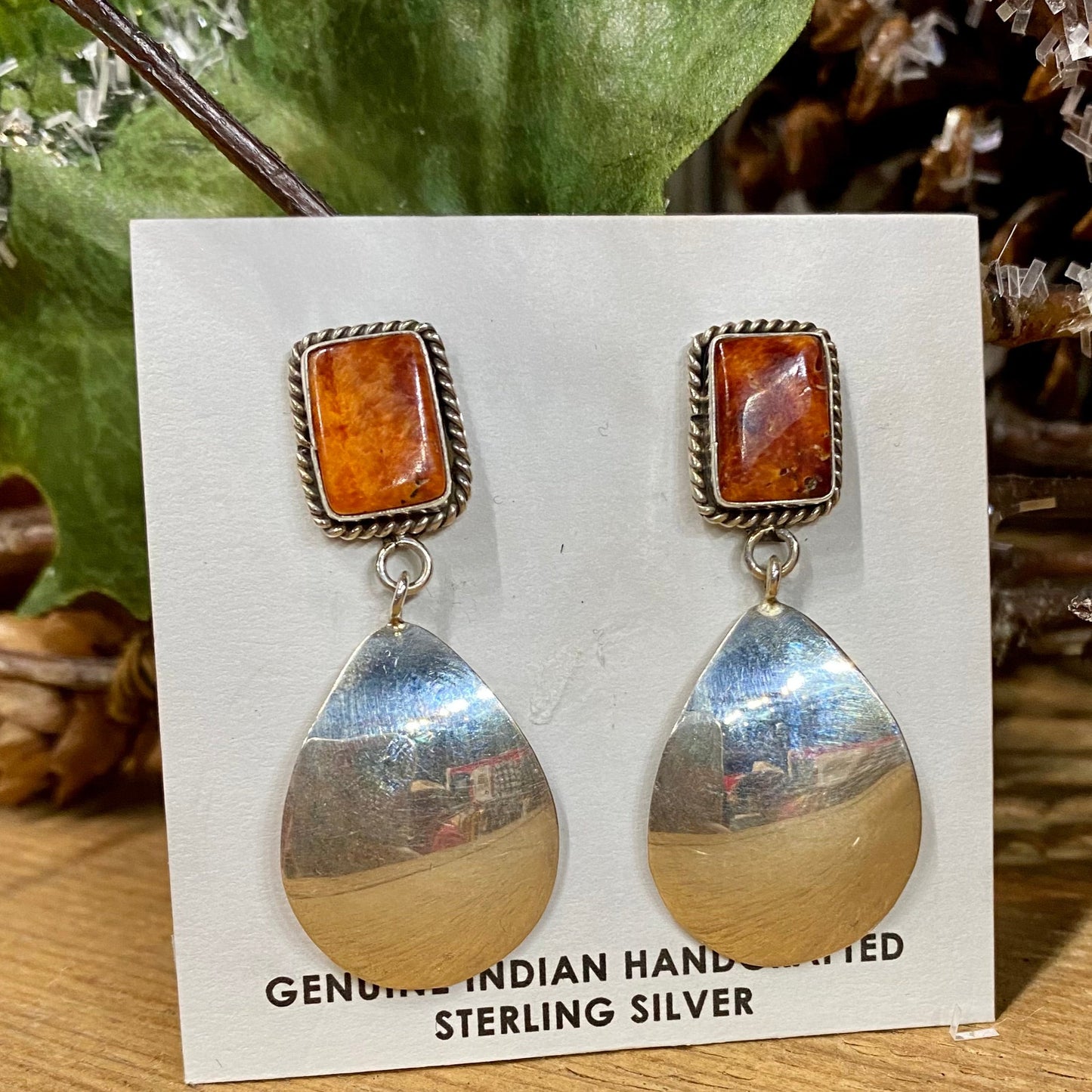 Stamped sterling orange spiny oyster post earrings with reflective mirror bottom. These spiny oyster Native American made earrings are stunning. They will make for an awesome statement piece in anyone's jewelry collection. Size: 2" Inch Length Stone: Spiny Oyster