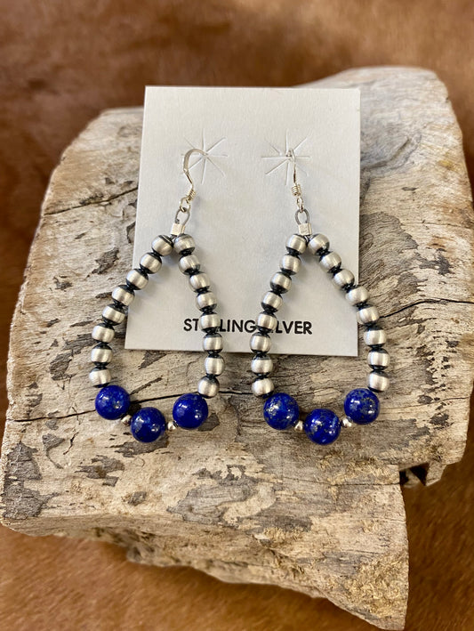 Gorgeous lightweight hand-strung Navajo pearl teardrop sterling silver lightweight earrings with three pieces of blue lapis stones at the bottom of each teardrop earring. The perfect earrings to add a pop of blue to any outfit! Size: 1.5” inches length x 1” inch width Stone: Blue Lapis & Navajo Pearl