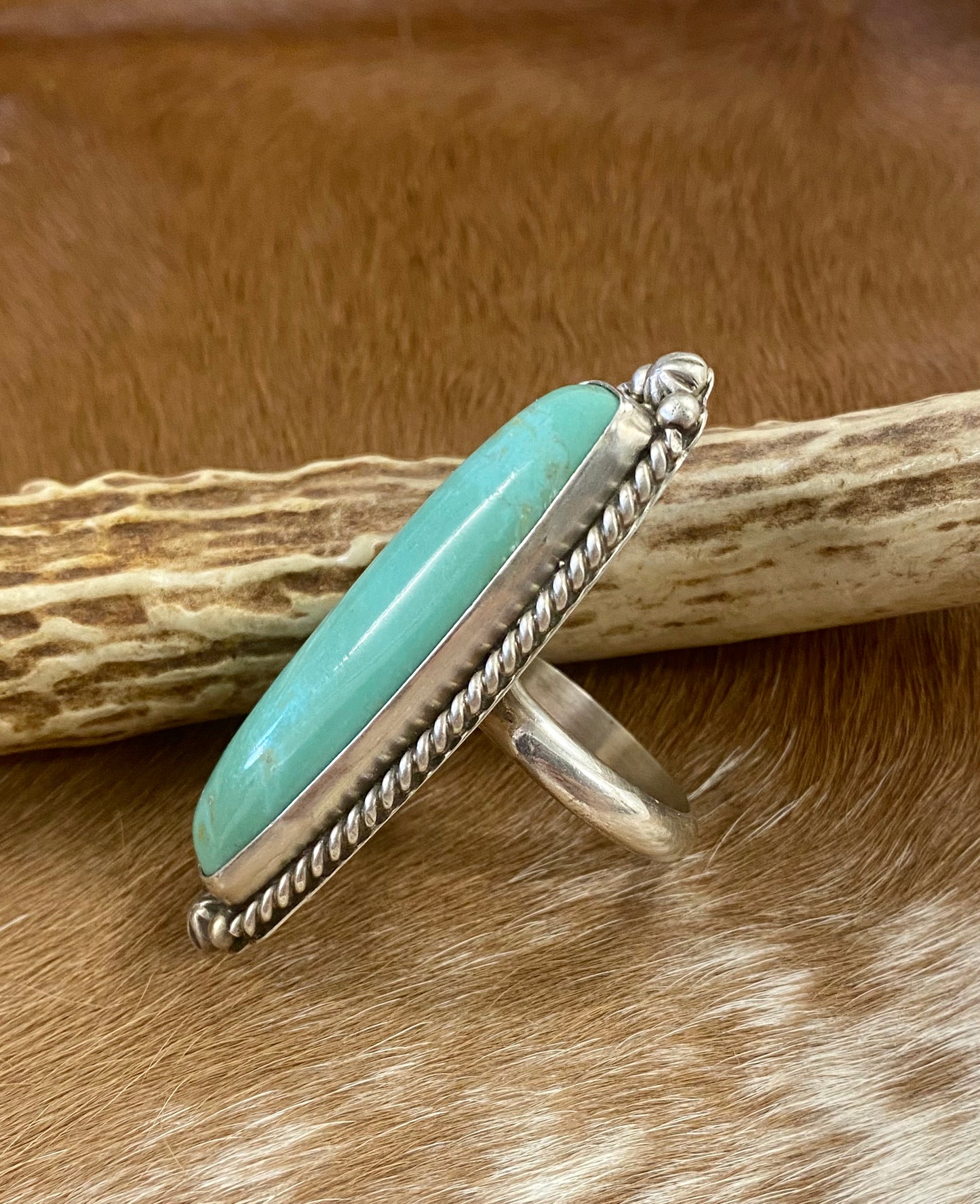 Sterling silver Tyrone Turquoise large statement single stone turquoise handmade unique size 9 ring. This piece is stamped STERLING and signed AL by an artist silversmith on the back of the ring. This ring is the perfect piece to add to anyone's jewelry collection! Size: Length 2 1/4” x 1” inches width Ring Size: 9 Signed: YES "AL" Stone: Tyrone Turquoise