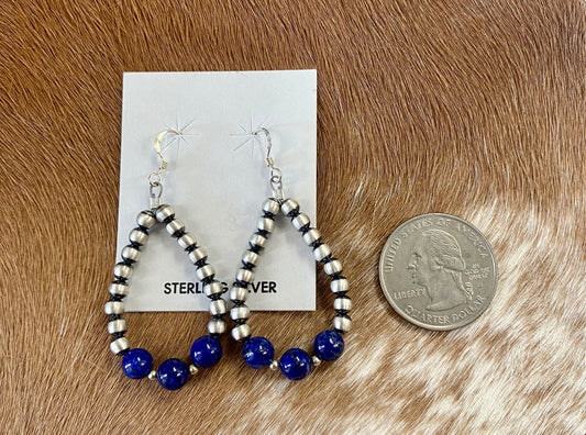 Gorgeous lightweight hand-strung Navajo pearl teardrop sterling silver lightweight earrings with three pieces of blue lapis stones at the bottom of each teardrop earring. The perfect earrings to add a pop of blue to any outfit! Size: 1.5” inches length x 1” inch width Stone: Blue Lapis & Navajo Pearl