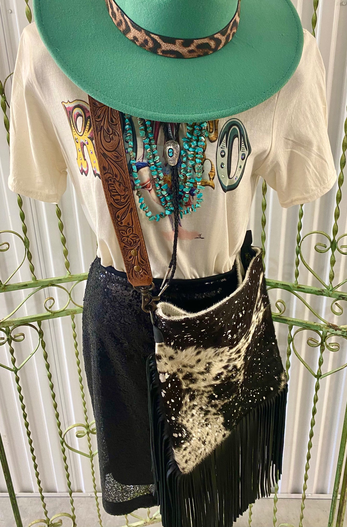 Large Black and White American Darling Western Crossbody Fringe Purse If you like cowhide and fringe and you're looking for a really cute crossbody purse that is also concealed carry, we've got just the purse for you! The Alex crossbody fringe purse is accented with silver metallic spots across the black and white hair on hide cowhide. It also has a removable tooled leather shoulder strap. It features 2 open pockets and 1 zipped pocket inside.