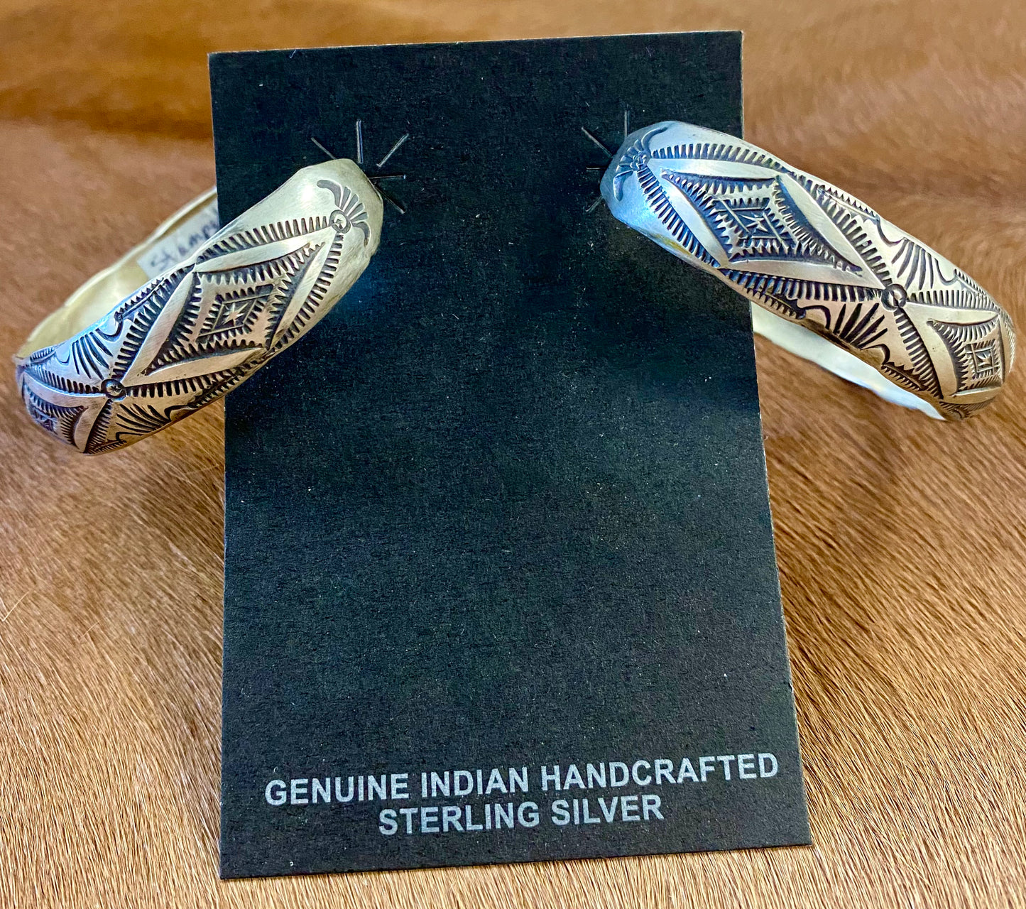 Stunning large statement Native American made sterling silver half hoop post stamped silver earrings. These are sure to make a statement when being worn with any outfit. They are so simple yet elegant. The perfect addition to anyone's jewelry collection! Size: 2” inch length Native American Handmade Stamped Silver Post Half Hoop Unique Earrings