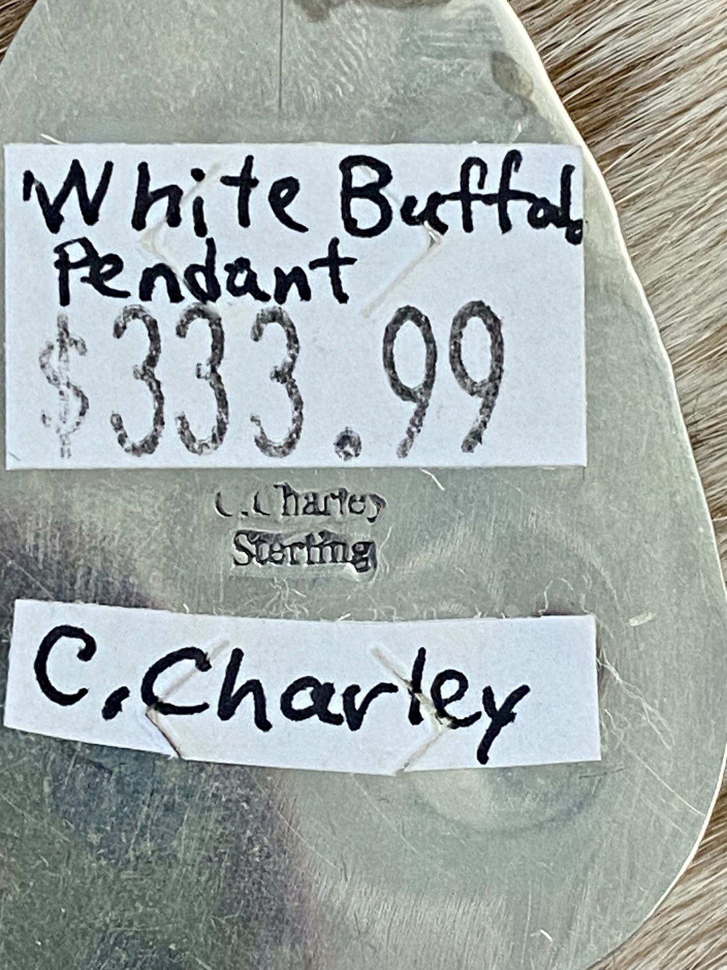 The perfect single-stone sterling silver unique Native American-made large White Buffalo pendant to add to any necklace. This piece will look gorgeous on a strand of Navajo pearls or a chain necklace. Stamped sterling and signed C Charley by Native artist silversmith. The perfect piece to add to your next outfit!   Size: 1 3/4” inches in length without bale, bale 1/2” inch. 1 1/4" inches in width   Signed: YES "C. Charley"   Hallmark/ Artist: C. Charley Stone: White Buffalo