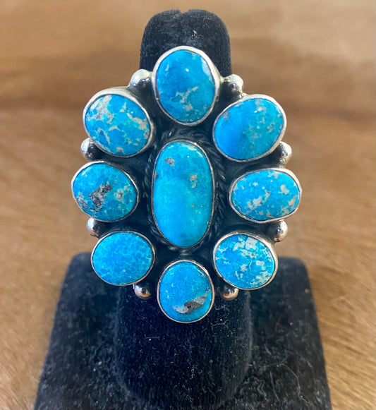 Gorgeous adjustable Kingman turquoise large cluster sterling silver ring. Nine unique turquoise stones grouped together. Stamped sterling and signed "AG" inside of a clover by Native American artist silversmith duo Arnold & Carleena Goodluck. Beautiful native made piece of art to add to your jewelry collection!    Size: 1.5” inch length   Signed: YES "AG"  Hallmark/Artist: Arnold & Carleena Goodluck   Stone: Kingman Turquoise 