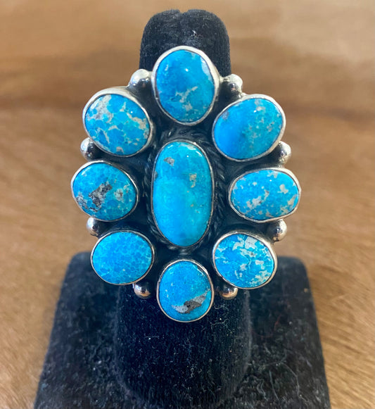 Gorgeous adjustable Kingman turquoise large cluster sterling silver ring. Nine unique turquoise stones grouped together. Stamped sterling and signed "AG" inside of a clover by Native American artist silversmith duo Arnold & Carleena Goodluck. Beautiful native made piece of art to add to your jewelry collection!    Size: 1.5” inch length   Signed: YES "AG"  Hallmark/Artist: Arnold & Carleena Goodluck   Stone: Kingman Turquoise