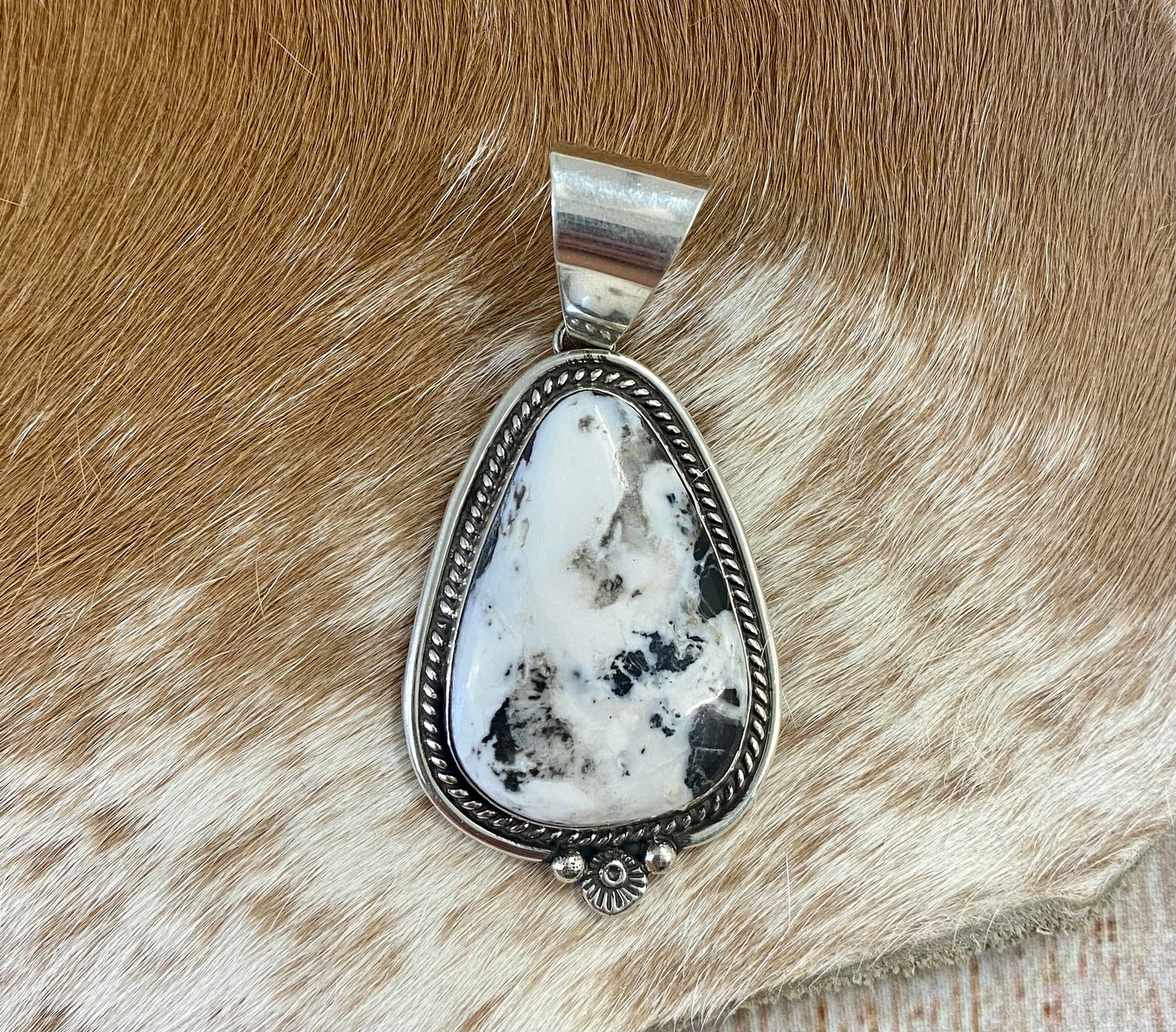 The perfect single-stone sterling silver unique Native American-made large White Buffalo pendant to add to any necklace. This piece will look gorgeous on a strand of Navajo pearls or a chain necklace. Stamped sterling and signed C Charley by Native artist silversmith. The perfect piece to add to your next outfit!   Size: 1 3/4” inches in length without bale, bale 1/2” inch. 1 1/4" inches in width   Signed: YES "C. Charley"   Hallmark/ Artist: C. Charley Stone: White Buffalo