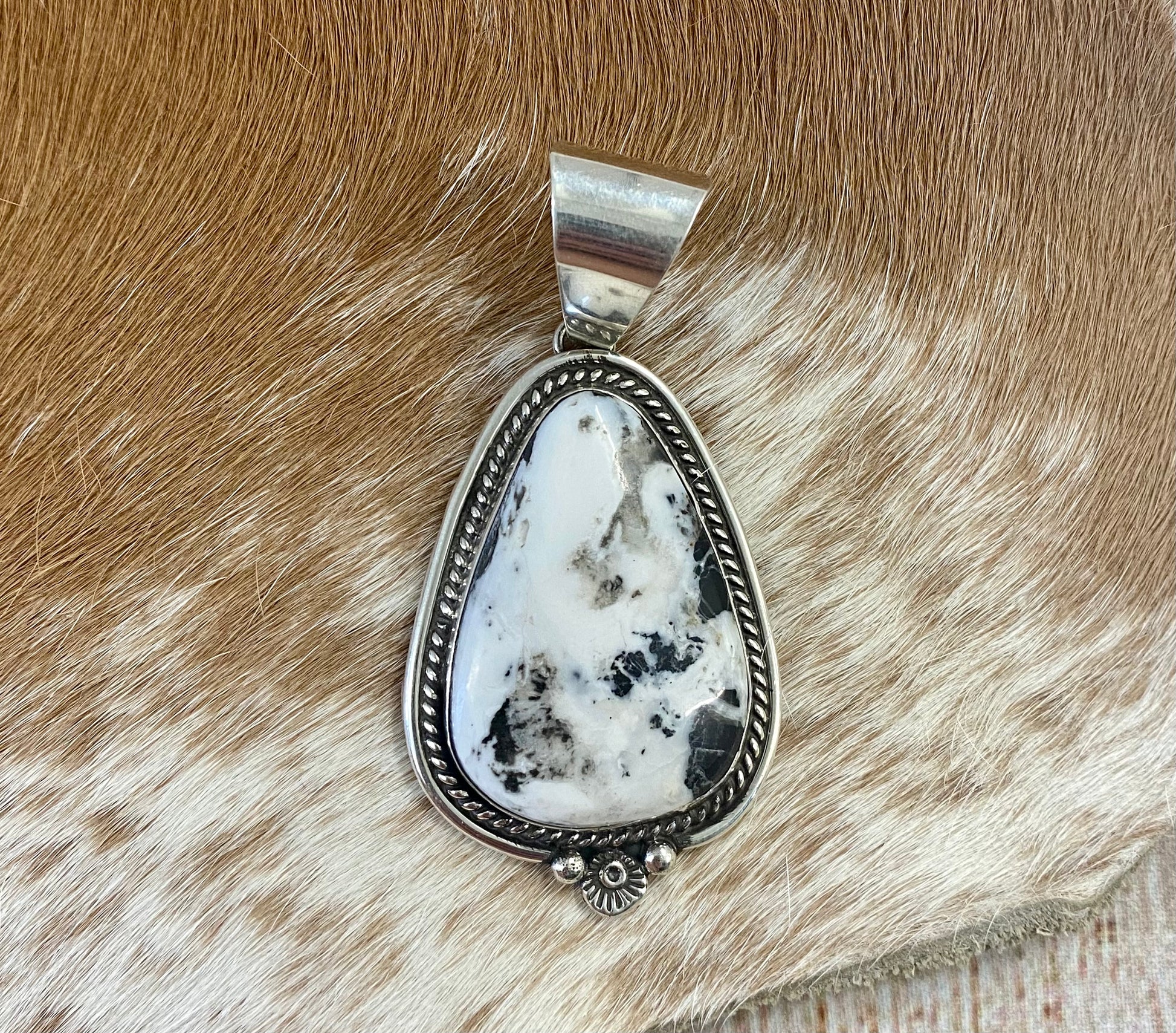 The perfect single-stone sterling silver unique Native American-made large White Buffalo pendant to add to any necklace. This piece will look gorgeous on a strand of Navajo pearls or a chain necklace. Stamped sterling and signed C Charley by Native artist silversmith. The perfect piece to add to your next outfit!   Size: 1 3/4” inches in length without bale, bale 1/2” inch. 1 1/4" inches in width   Signed: YES "C. Charley"   Hallmark/ Artist: C. Charley Stone: White Buffalo