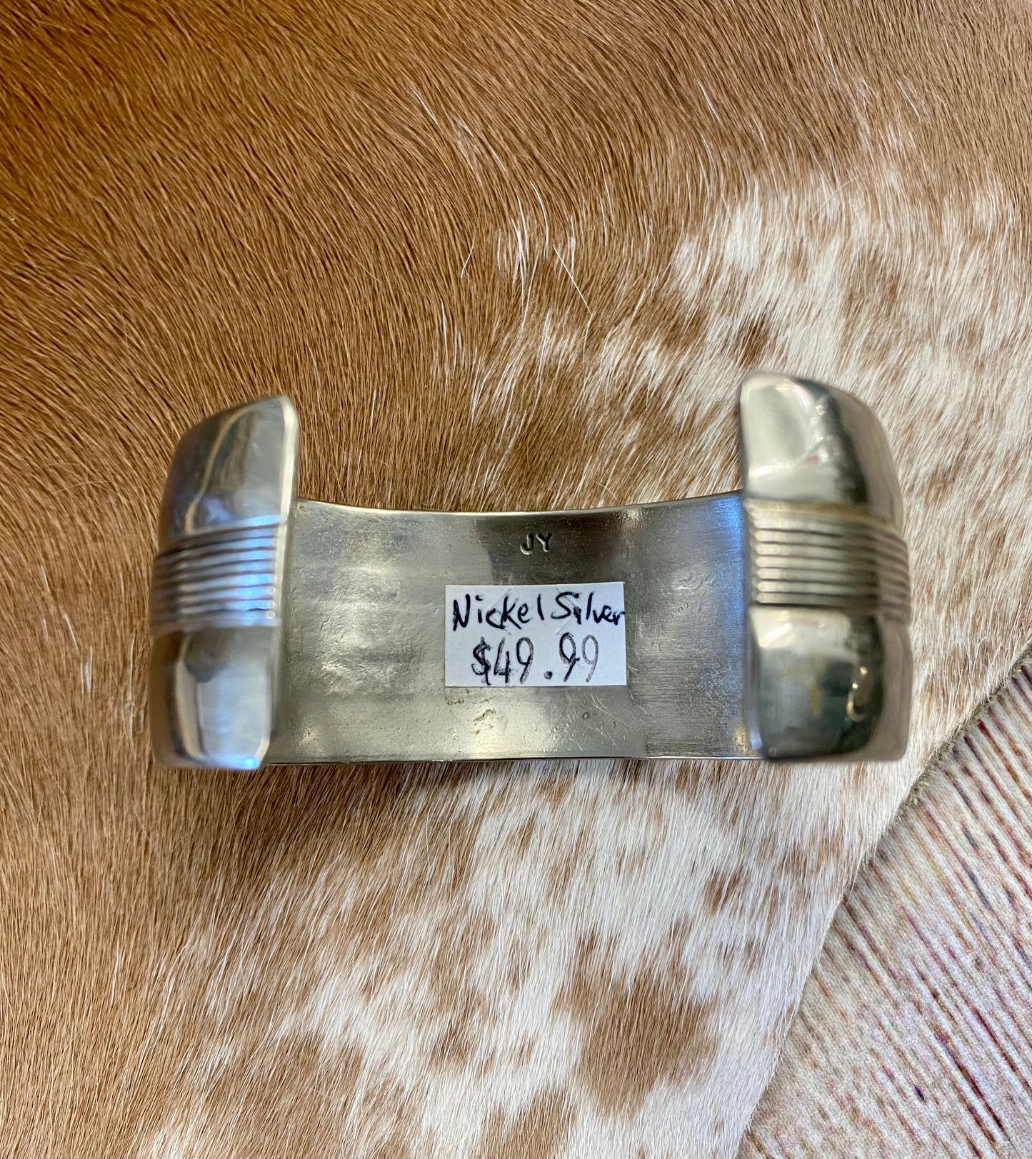 Beautiful unique simple Nickel Silver handmade cuff. Signed JY by artist inside of the cuff band. The perfect piece to add to you or your loved ones jewelry collection. Signed: YES "JY" Material: Nickel Silver Size: 5 1/2” inch length inside measurement + 1 1/4” inch gap 1” inch length width Handmade Navajo Made Nickel Silver Cuff Signed JY By Artist