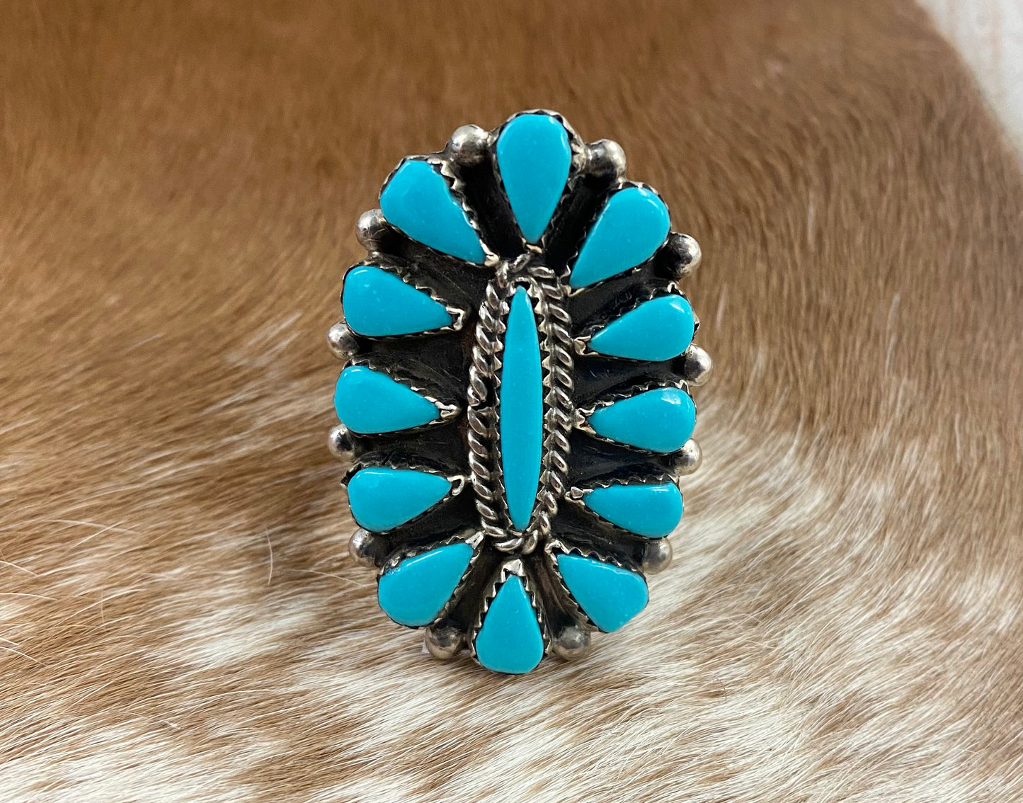 Sleeping Beauty turquoise traditional cluster sterling silver ring. Stamped sterling and signed on the back by a Zuni Native American artist silversmith. Available in size 12 1/2. The perfect piece to add to your accessory wardrobe and jewelry collection.   Size: 1.5 Inches Length X 1” Inch Width    Stone: Sleeping Beauty Turquoise   Signed: YES