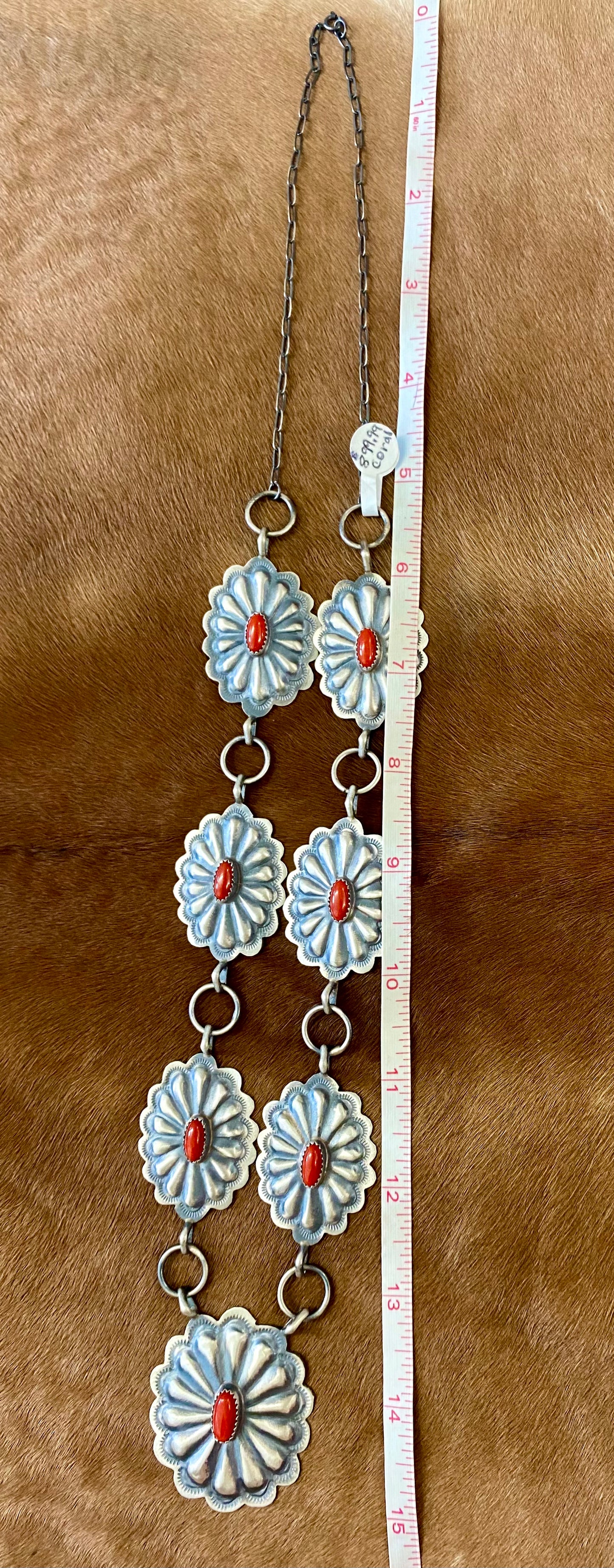 Beautiful seven silver and coral concho long 30" inch length sterling silver Native American made necklace. The piece is stamped sterling and signed "DM" on the back of the necklace. Size: 30" Inches length Stone: Coral Signed: YES "DM" Handmade Concho Coral Sterling Silver Native American Made Necklace