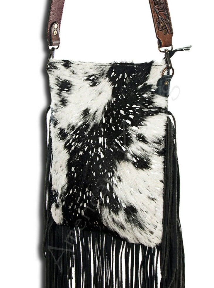 Large Black and White American Darling Western Crossbody Fringe Purse If you like cowhide and fringe and you're looking for a really cute crossbody purse that is also concealed carry, we've got just the purse for you! The Alex crossbody fringe purse is accented with silver metallic spots across the black and white hair on hide cowhide. It also has a removable tooled leather shoulder strap. It features 2 open pockets and 1 zipped pocket inside.